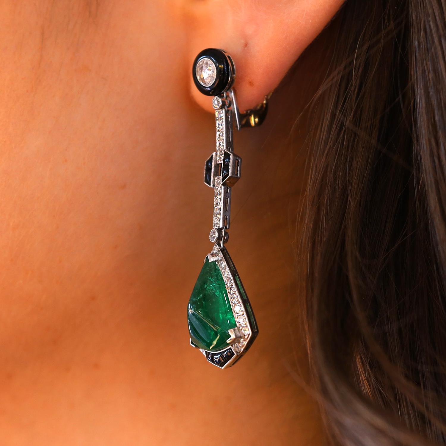 A lush and sleek pair of Art deco revival emerald, onyx and diamond dangle earrings. These magnificent 