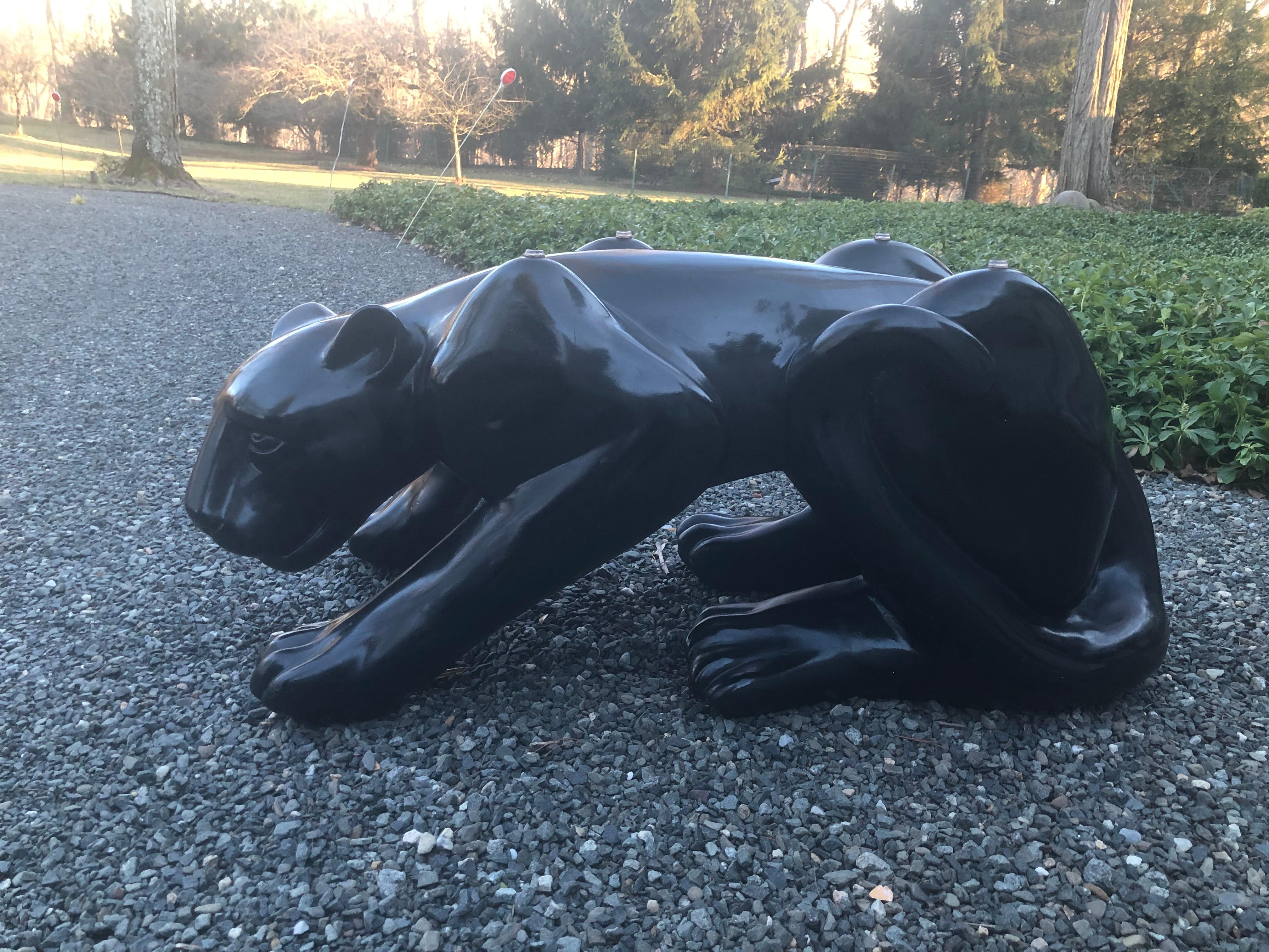Striking 1970s ceramic Black Panther cocktail table having sculptural about to pounce panther base with expressive face and oval glass top. Table is very heavy and in very good condition. The glass has no scratches and is oval with a polished edge,