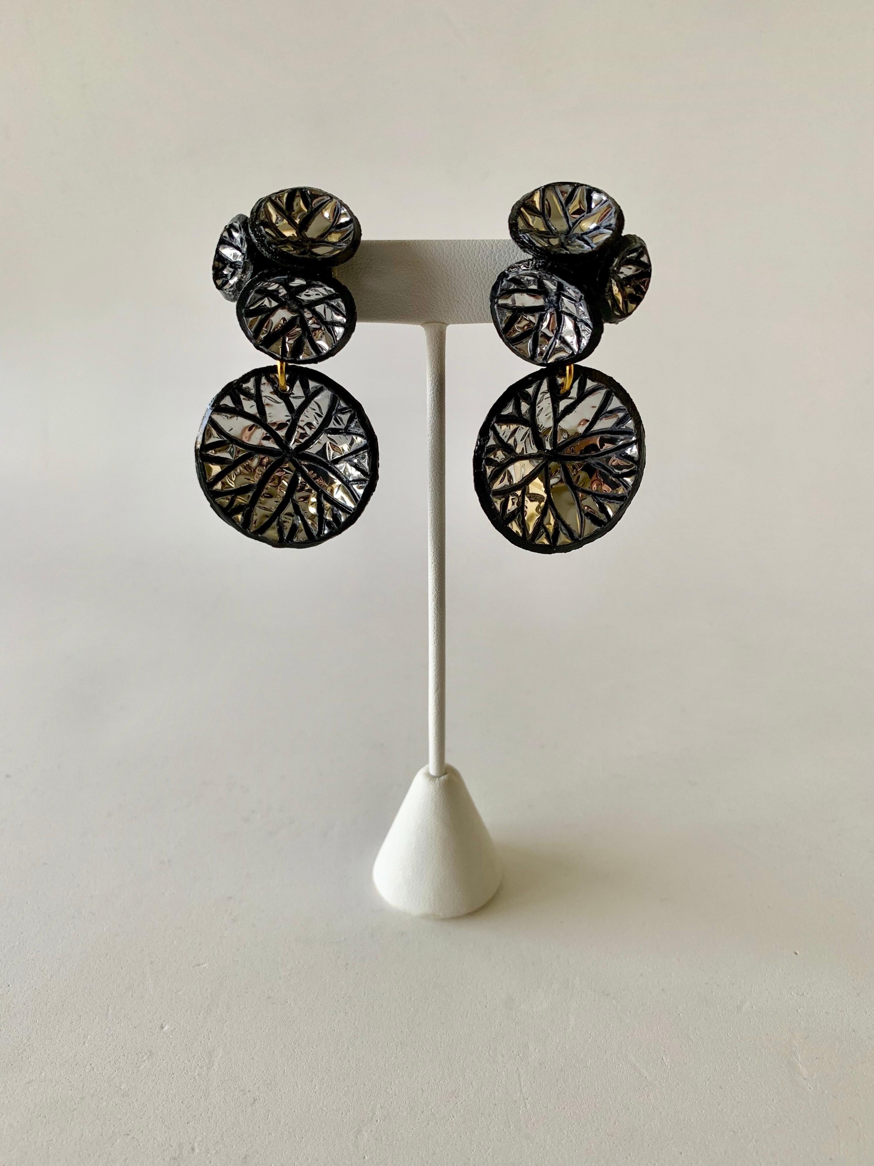 Light and easy to wear, these handmade artisanal contemporary disk earrings were made in Paris by Cilea. Concave black resin discs embellished with metallic silver leaf, clustered together to form a powerful statement piece - signed Cilea Paris on