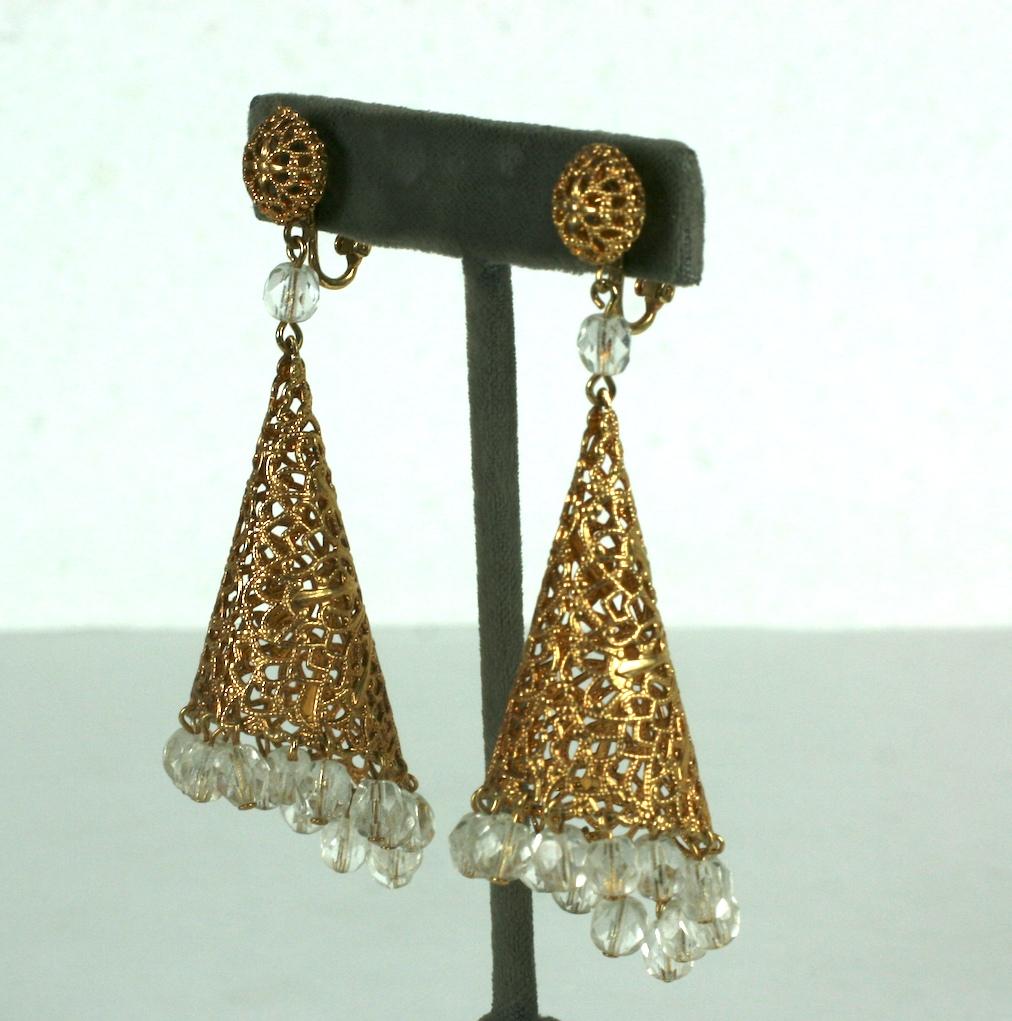 Dramatic Crystal Filigree Drop Earrings from the 1960's. A gilt square of filigree metal is curled into a cone and crystal drops are added along the edge. A filigree ball is on the ear clip. Clip back fittings.
1960's USA. possibly made by