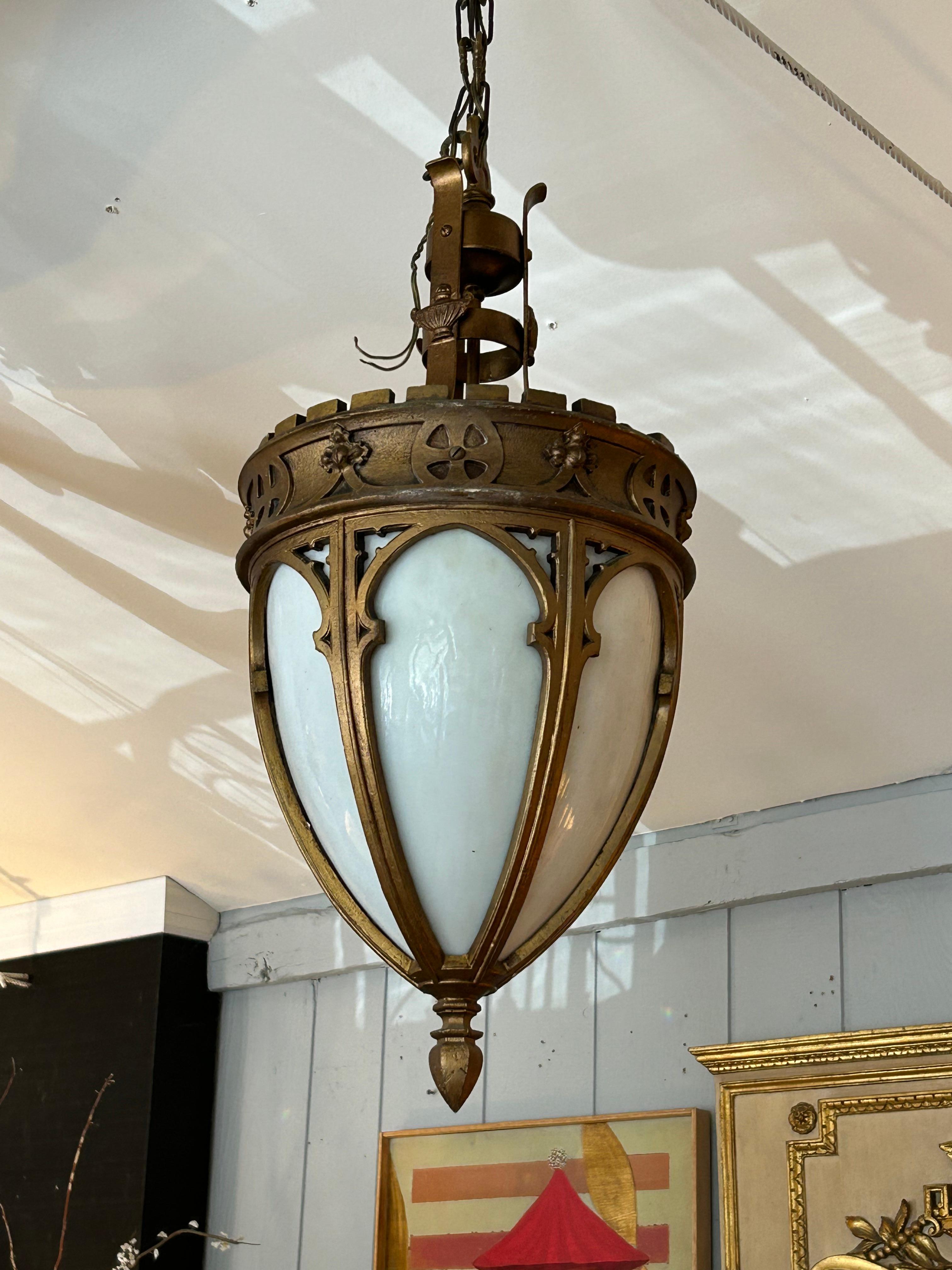 Unusual striking Gothic style gilt wood light fixture having milk glass inside.  One 60 watt bulb and 12” of chain.