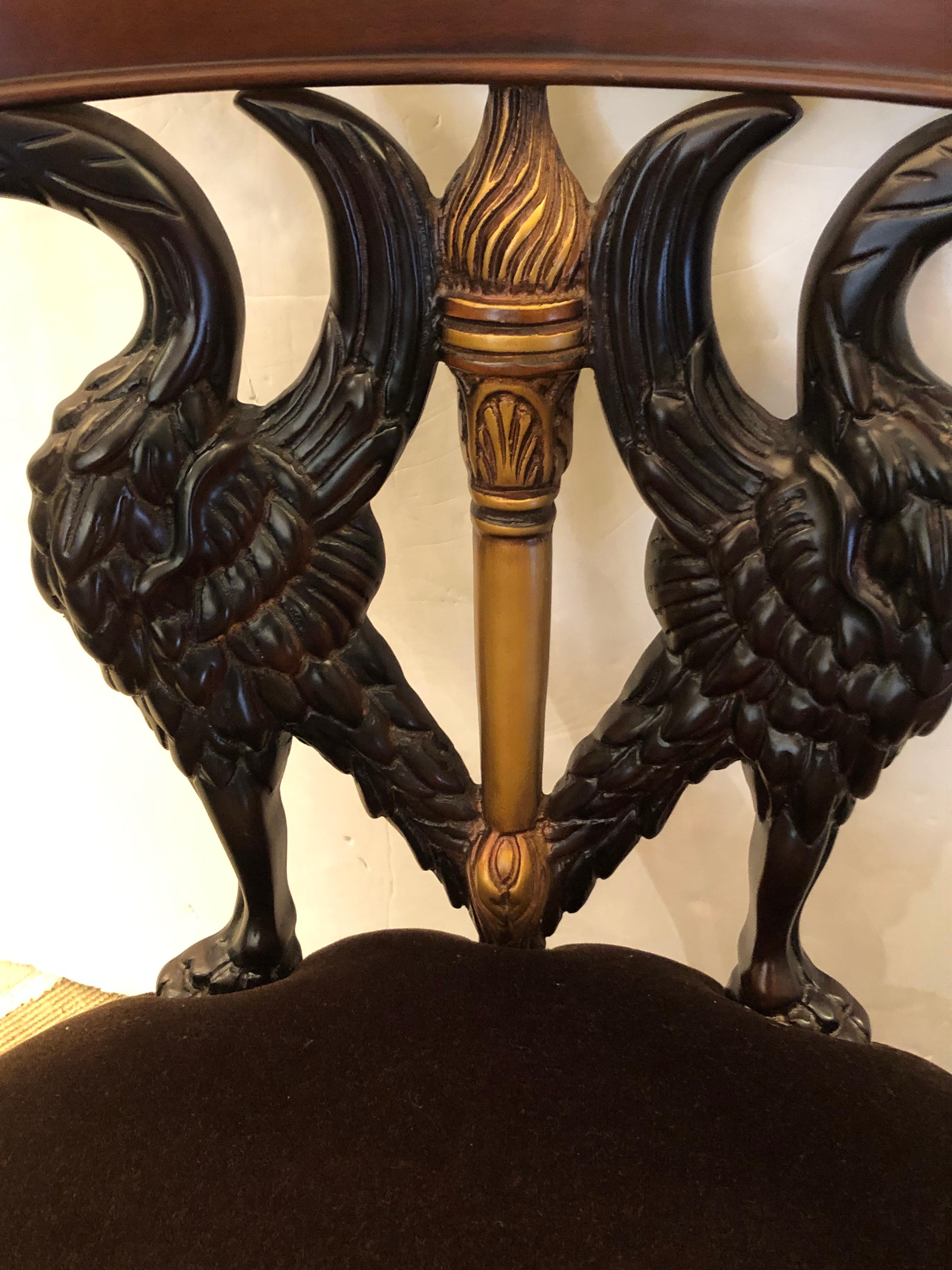 Dramatic carved wood armchair in mahogany, ebonized wood and gilded elements having elegant swan motif with arms that are the sinous necks of the birds.  Incredible flourishes in gold include a central torch, leaf like handrests and carved fan