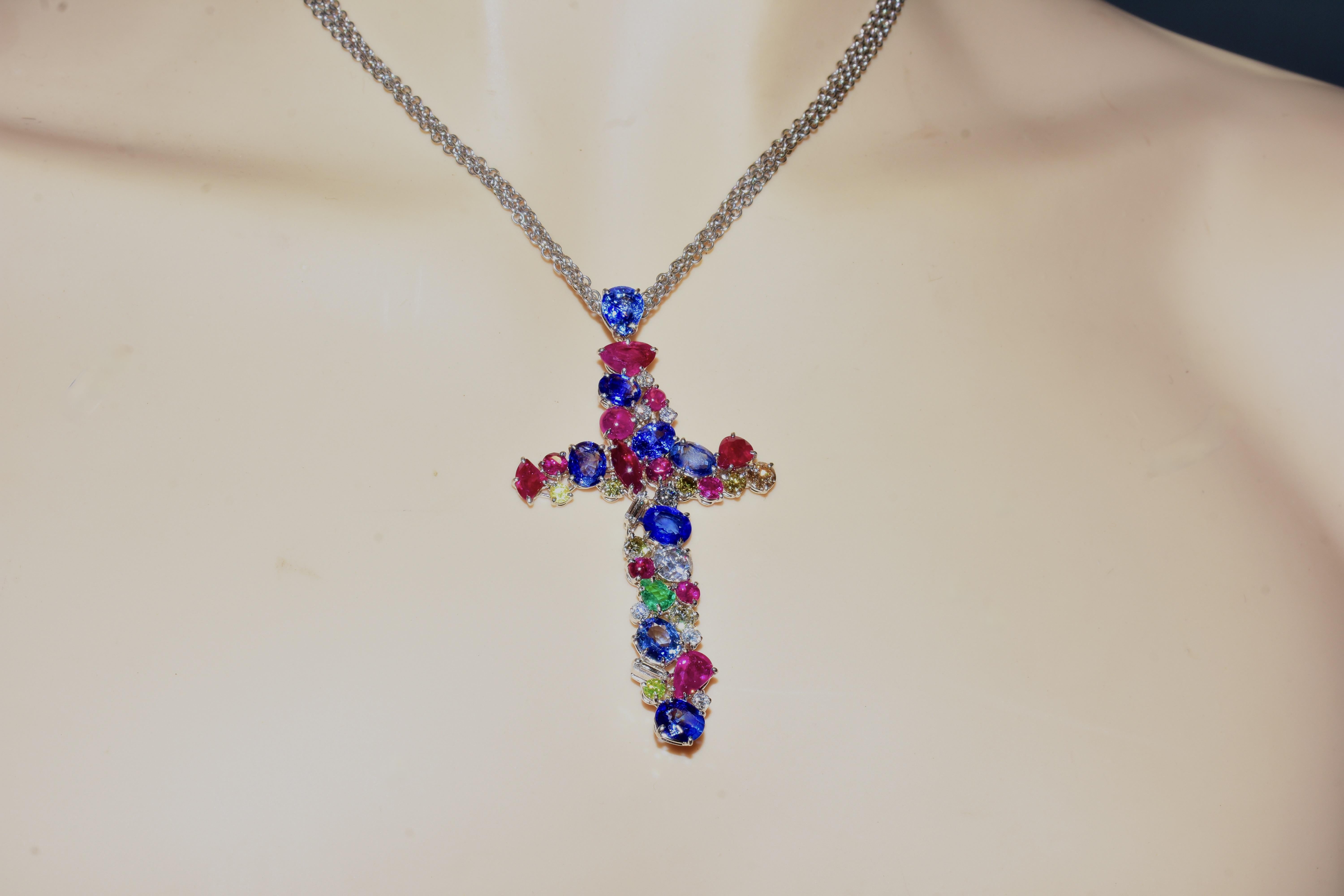 Cross Pendant set with fine diamonds and gemstones.  Seemingly at random in a juxtaposition,  thirty eight white diamonds, colored diamonds and colored stones are prong set in no particular order in this 18 carat white gold cross.  Just as there is