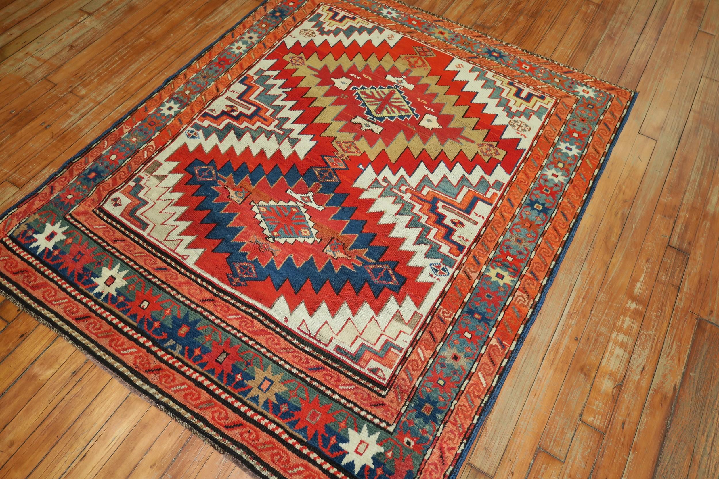 An early 20th century geometric Karabagh rug with coral blue, green accents on an ivory ground, circa 1920.

Measures: 4'3