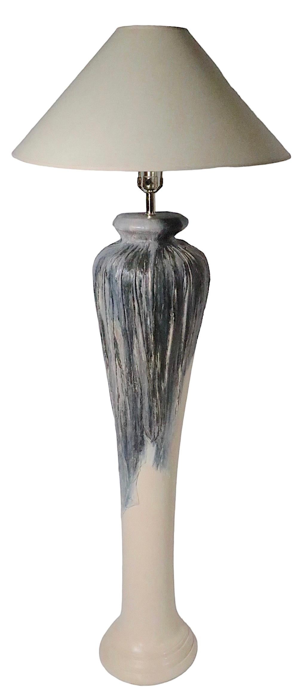 Dramatic oversize ceramic floor lamp of bulbous form with contrasting dark toned, textured glaze at the upper section, which appears to drip down onto the smooth creme colored bottom section. The lamp is in very good original, clean and working