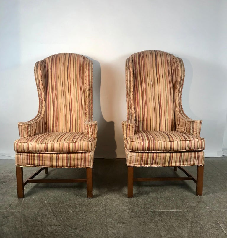 Dramatic pair of wing back scroll arm chairs attributed to Kittinger, Classic styling, presently slip covered, super quality frames, hand delivery avail to New York City or anywhere en route from Buffalo NY.