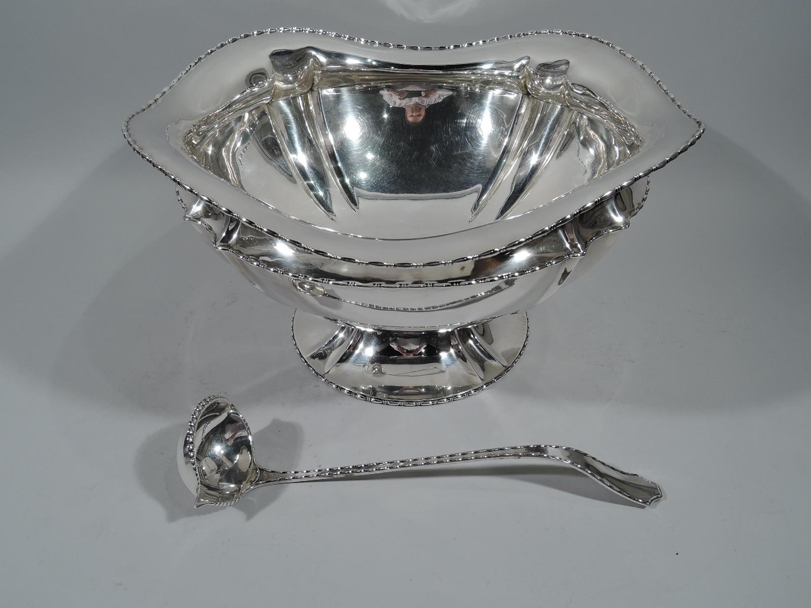 Dramatic sterling silver punch bowl and ladle in Marquise pattern. Made by Tiffany & Co. in New York, circa 1910.

Punch bowl: Curved and round with concave neck and wavy rim and raised and spread foot. Bowl and foot “paneled.” Bead-and-reel