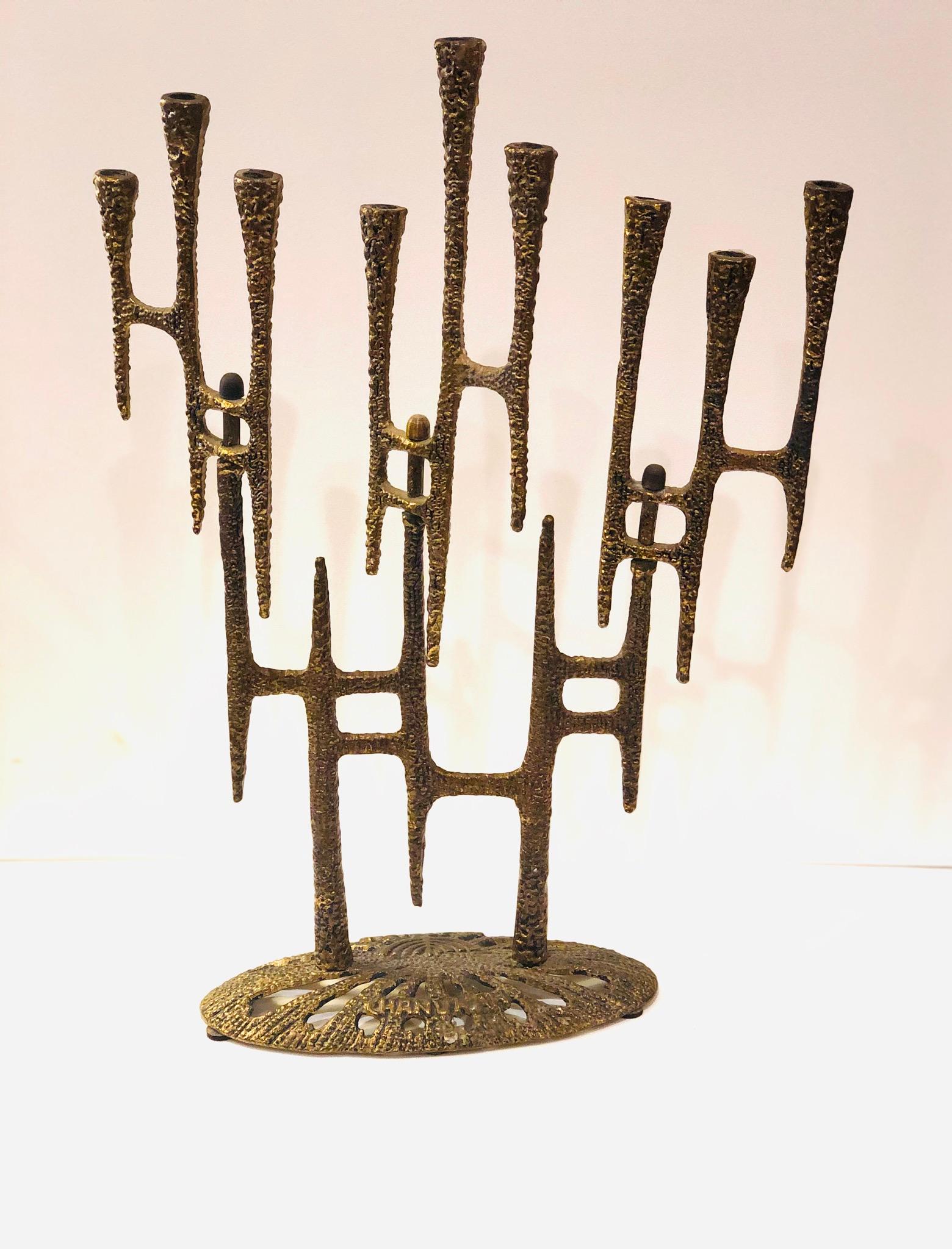 Rare and Brutalist pattern menorah with beaded texture to brass metal, 3 sets of 3 candle cups that are free to rotate at an axis, each cup hole is over 1/4 inch in diameter
Signature: underside marked Weinberg, made in Israel, base marked