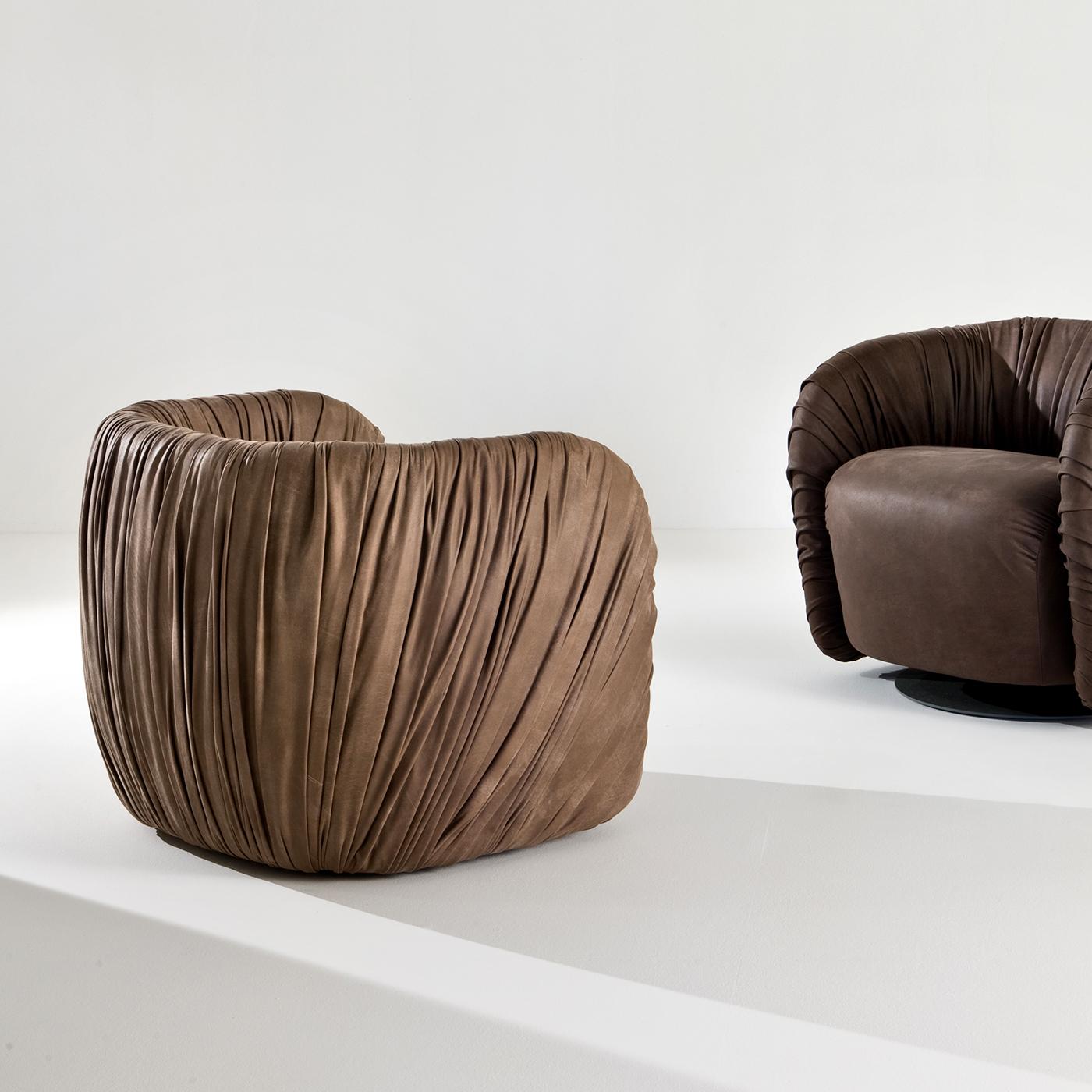 Cette superbe chaise longue est un objet de décoration fonctionnel qui sera le point fort d'une entrée moderne, d'un salon contemporain ou d'une chambre à coucher minimaliste. La silhouette confortable du fauteuil est rembourrée et revêtue de cuir,