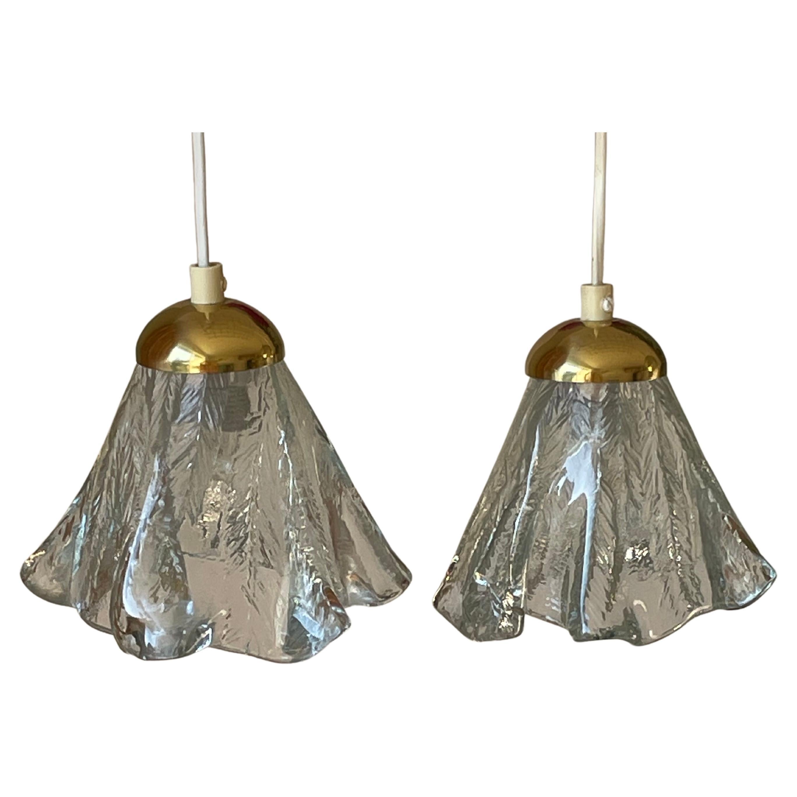 Pair of beautiful organic modern art glass pendants attributed to Orrefors. Beautifully draped mouthblown glass with lined textured pattern on the inside while smooth on the outside. Each item has a unique organic silhouette resembling flowing