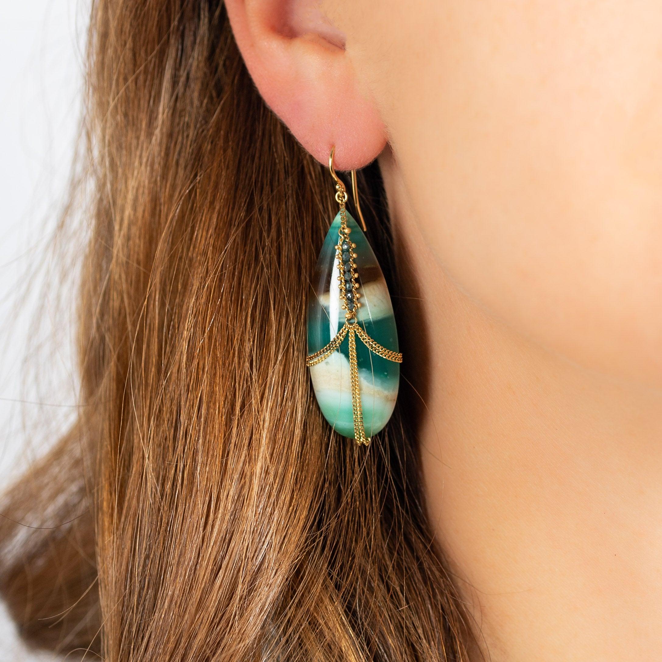 The colorway of these two Petrified Wood and Boulder Opal teardrops reminds us of sunrise over an ancient forest, the wide expanse of the sky swirled with light and shadow above a velvety green vista. We honor the beauty of these exquisite natural