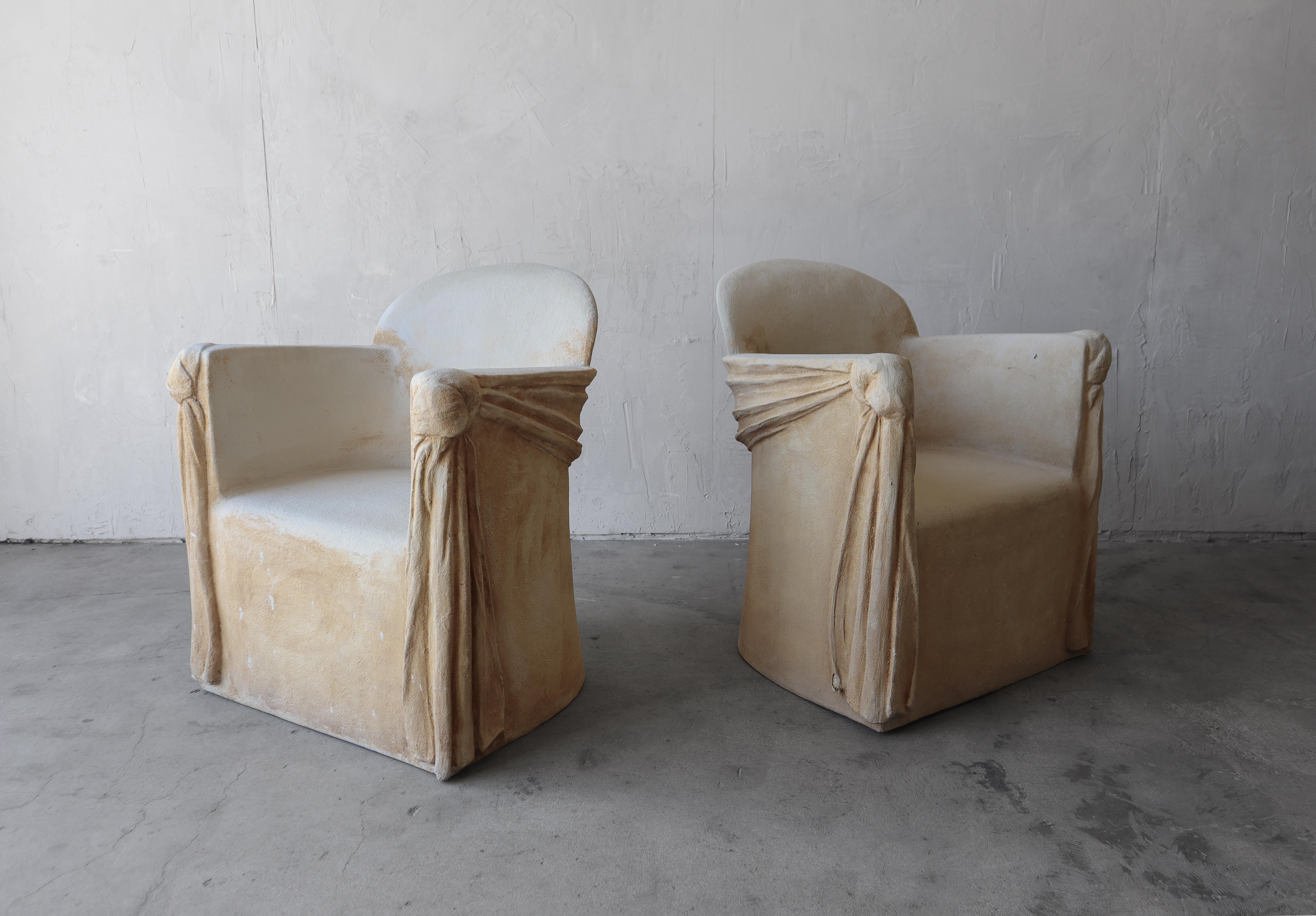 We just love this pair of sculptural pair of Trompe-l'oeil draped plaster and fiberglass chairs. They have been finished to look like stone. They achieve a very unique and artistic look. They have lots of depth and texture. They are the perfect