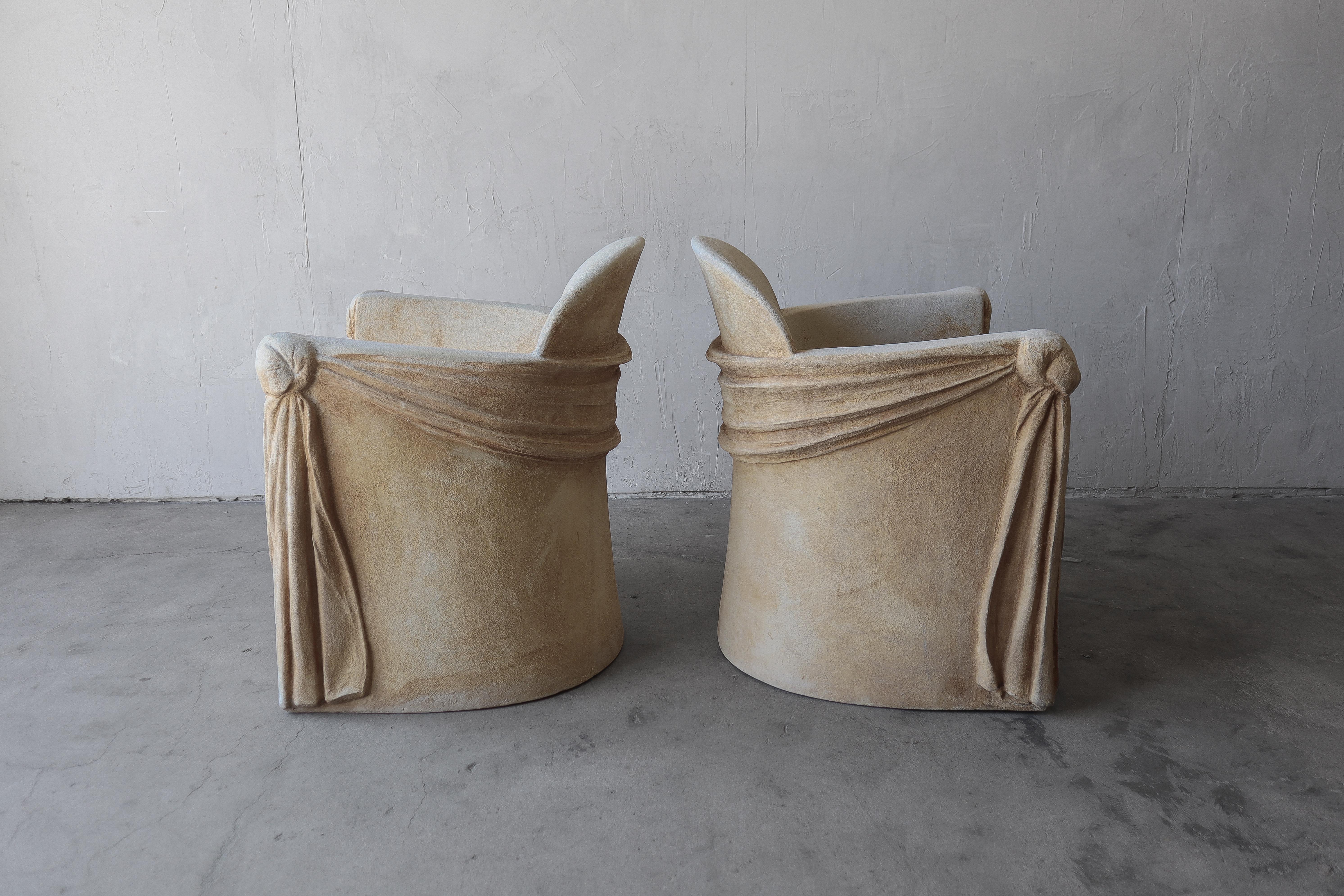 Adoriamo questa coppia di sedie scultoree in gesso e fibra di vetro con drappeggio Trompe-l'Oeil. Sono stati rifiniti in modo da sembrare di pietra. In questo modo si ottiene un look unico e artistico. Hanno molta profondità e consistenza. Sono i