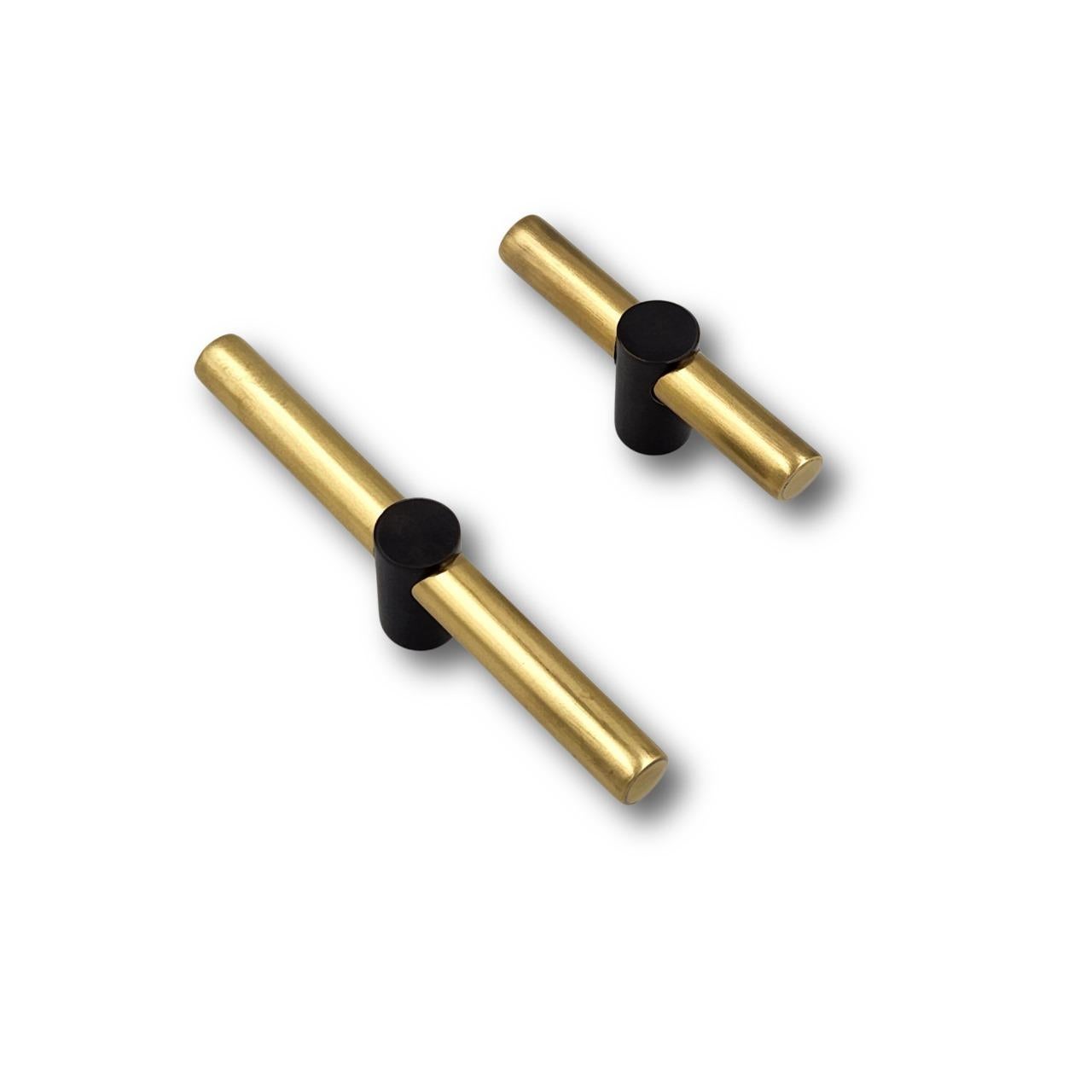 This 12 cm drawer pull embodies the geometric rigor of the Art Deco style through a clean tubular silhouette. Made of aged gold brass, it features a central insert in gunmetal finish, creating a subtle interruption in the visual flow.

The contrast