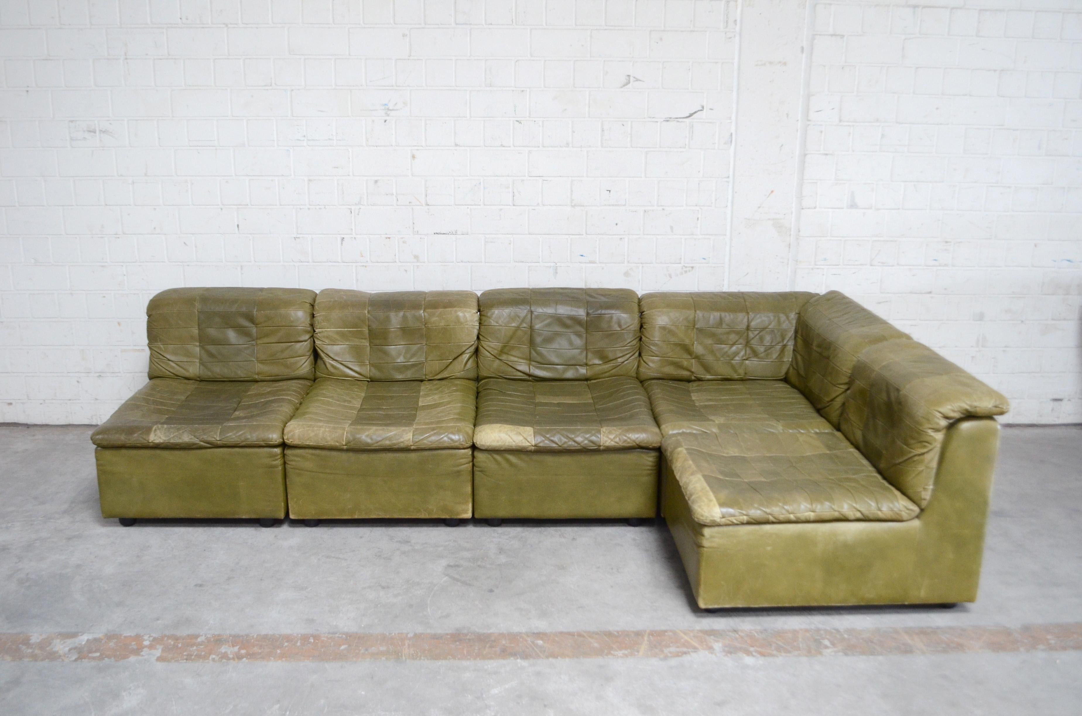 Dreipunkt International module leather sofa.
German design from Dreipunkt from the 1970s.
Aniline leather in olive green classic patchwork design.
It consists 5 elements. 1 corner and 4 m single element
Originally on 1 chair there were armrests