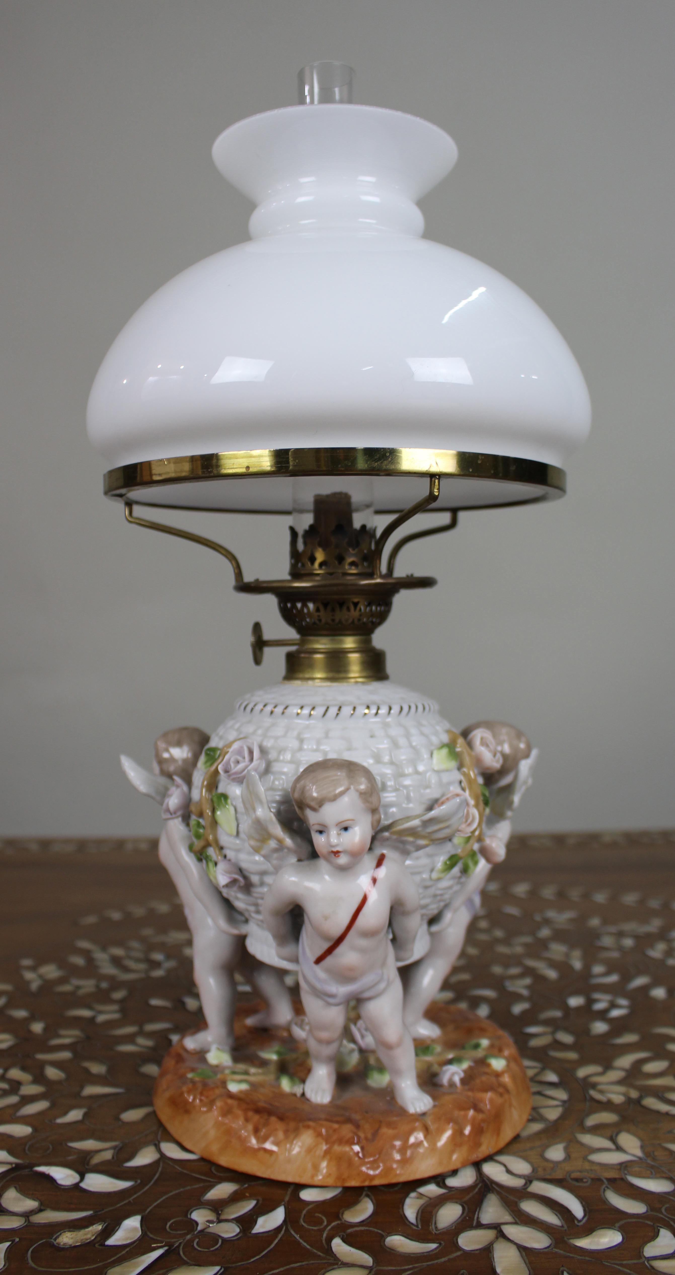Dresden Porcelain Öllampe mit Putten, um 1890

Eine dekorative Porzellan-Öllampe aus dem späten 19. Jahrhundert, datiert um 1890. Der Sockel ist fein modelliert mit drei geflügelten Putten, die auf einem naturalistischen Hügel stehen und ein