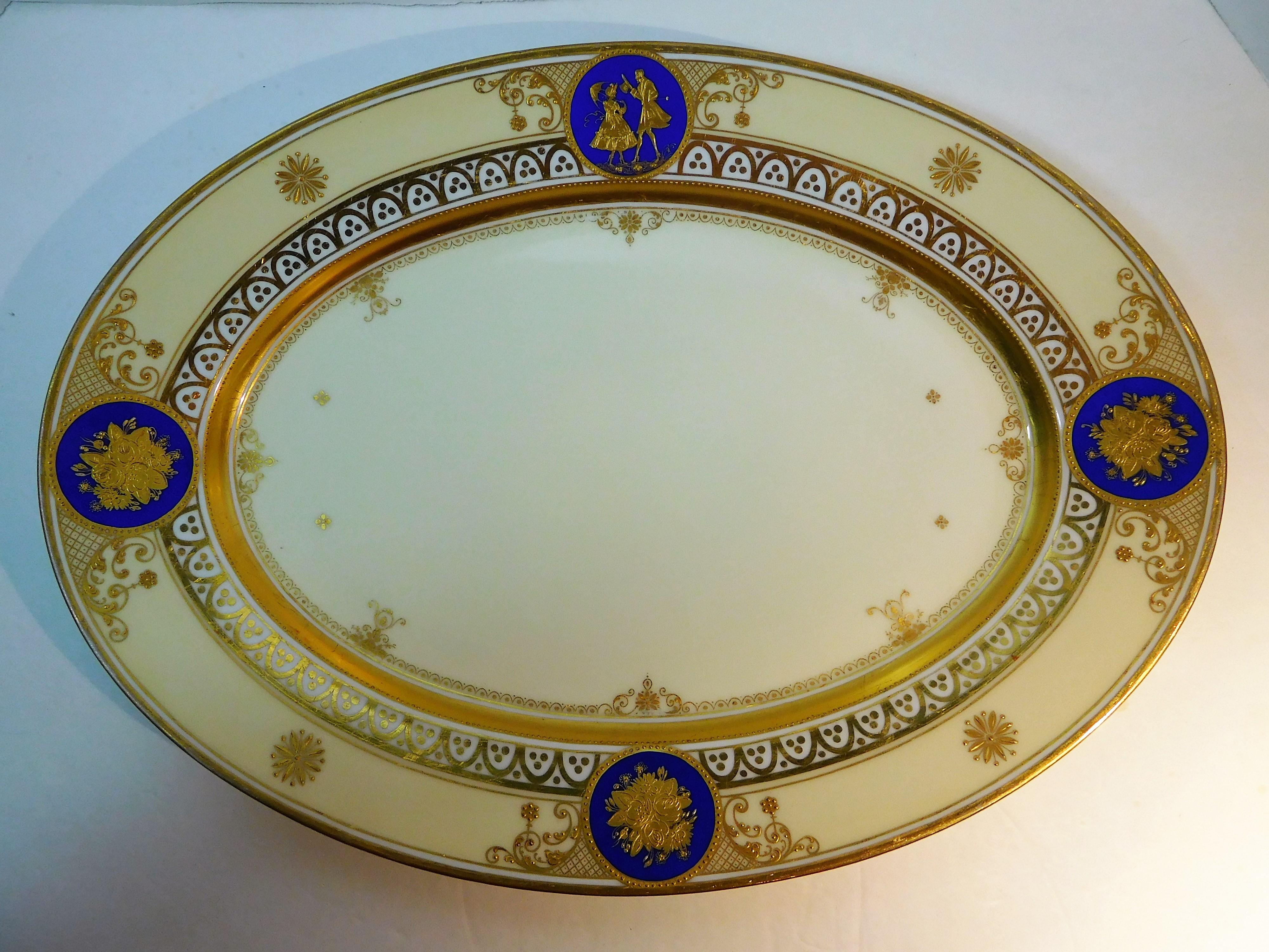 This German fine porcelain large oval platter is from the Dresden atelier of Ambrosius Lamm (active 1887-1934), and was hand painted in enamels and hand-burnished with double-gold incrustation in his studio. It is signed on the bottom with his logo,