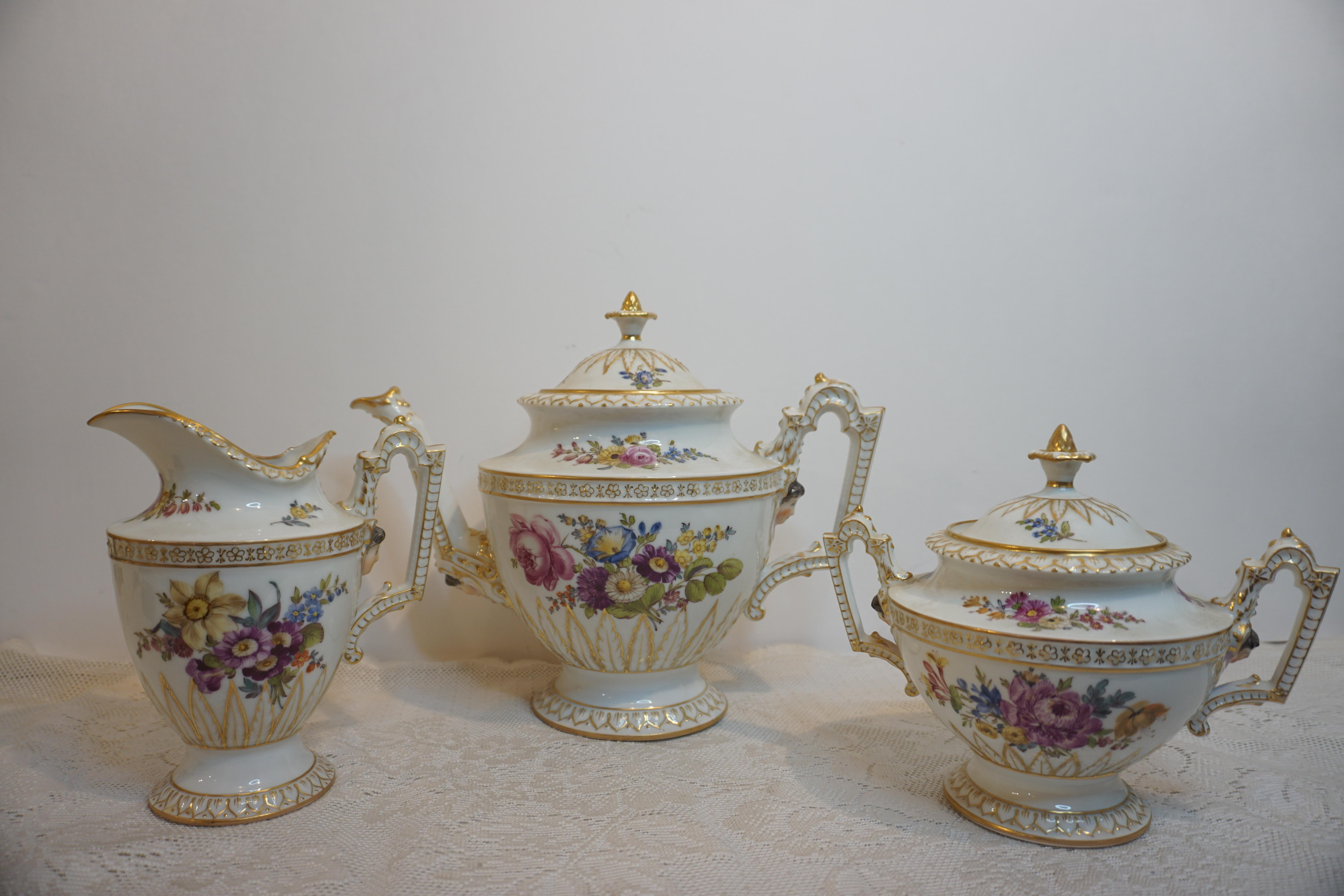 Je vous propose ce fabuleux service à thé Helena Wolfson Dresden décoré de bouquets de fleurs peints à la main et de visages de dames figurés en relief. Il comprend une théière, un sucre et un crémier. Il a été fabriqué entre les années 1890 et
