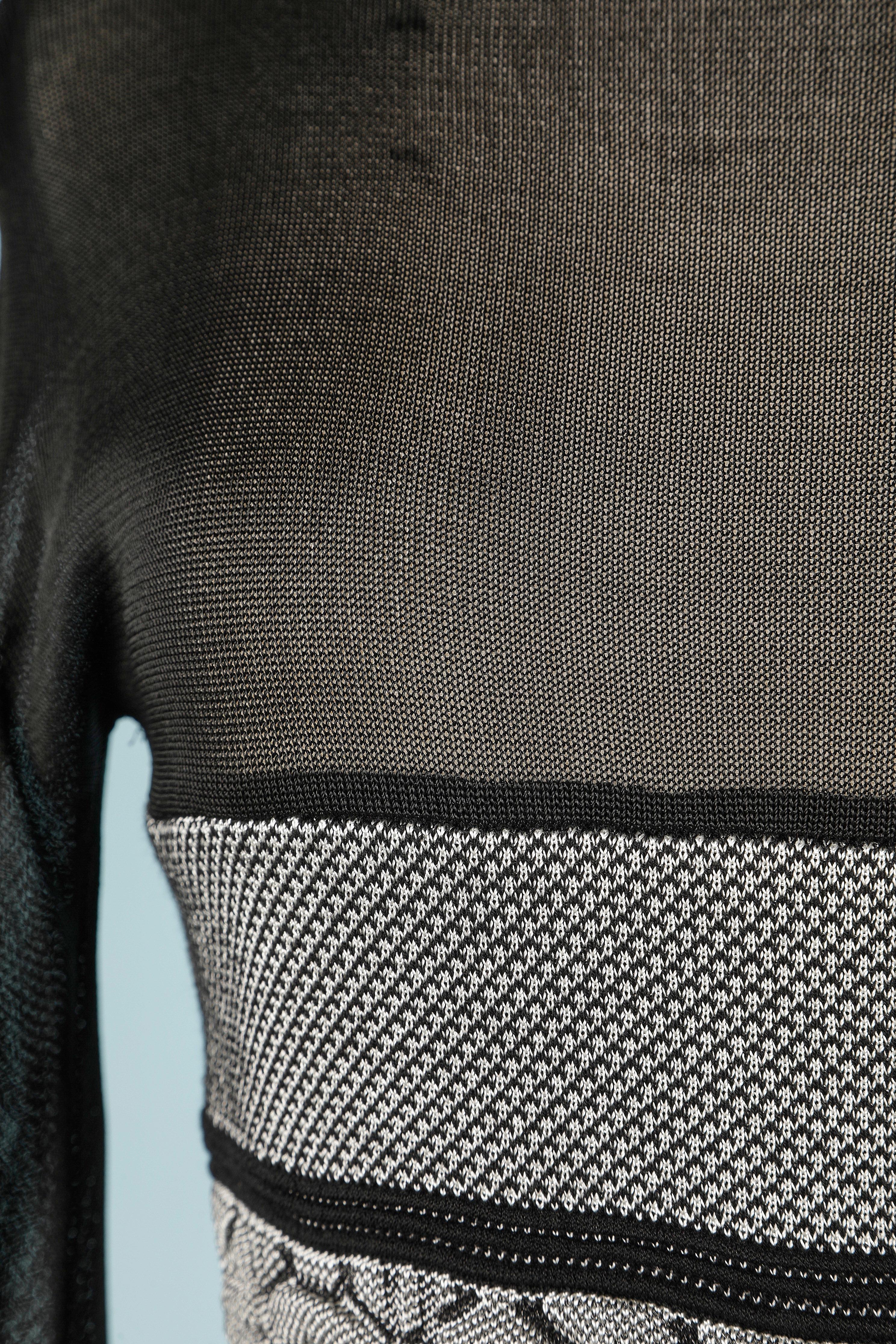 Abito e gonna in maglia di rayon e taffetas con jacquard 3D in vita. Gonna a portafoglio in taffetas attaccata alla maglia. 
Composizione del tessuto dell'abito: 45% rayon, 40% seta, 10% lana, 3% poliammide, 3% nylon, 2% elastan, 2% gomma
Gonna: 35%