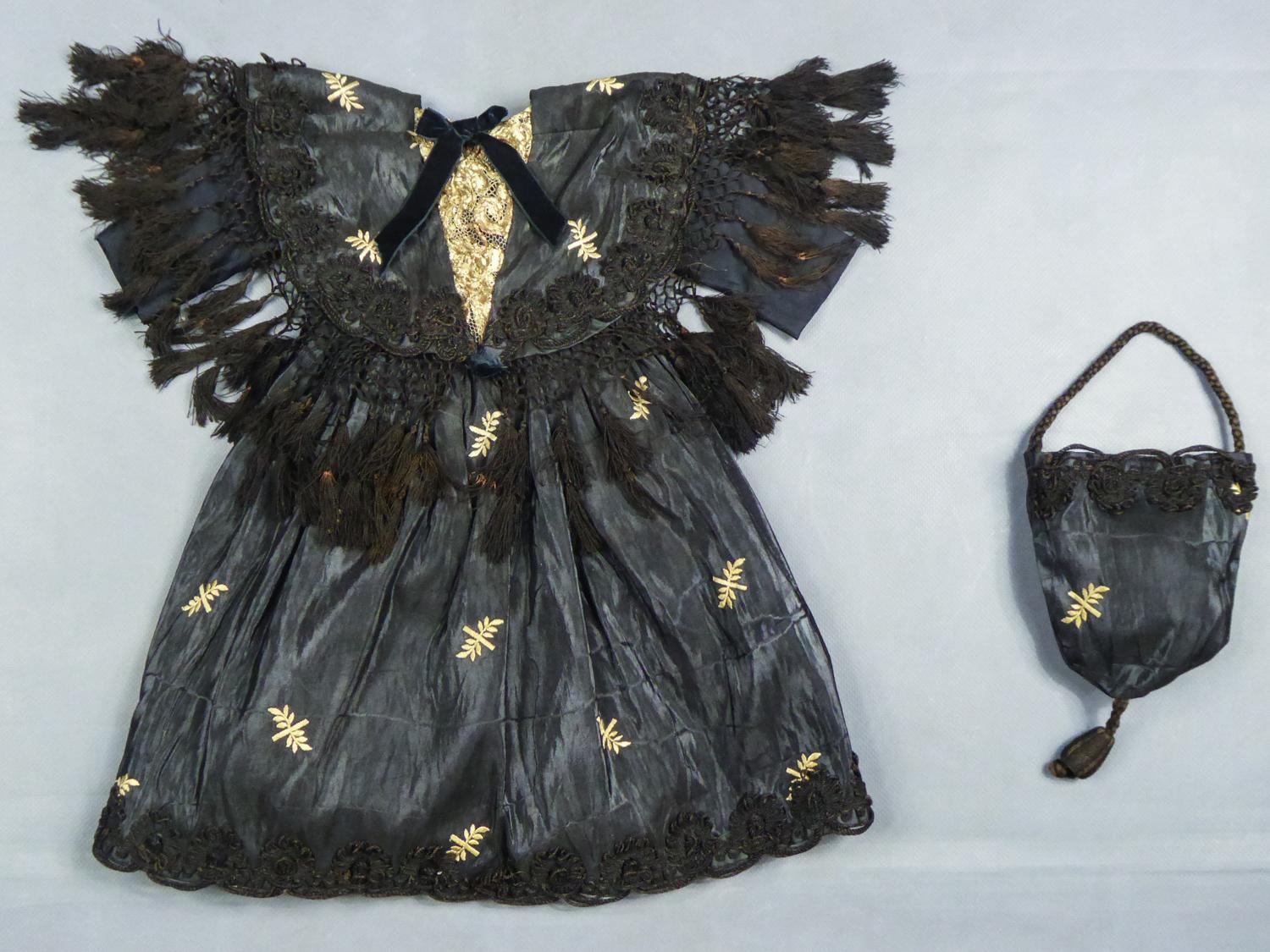 Circa 1860/1900
France 

Beautiful dress for doll or young girl and its reticule from the Second French Empire period in black silk moire embroidered with a fine pattern of leafy stems. Beautiful work of black trimmings cords appliqued to the shawl