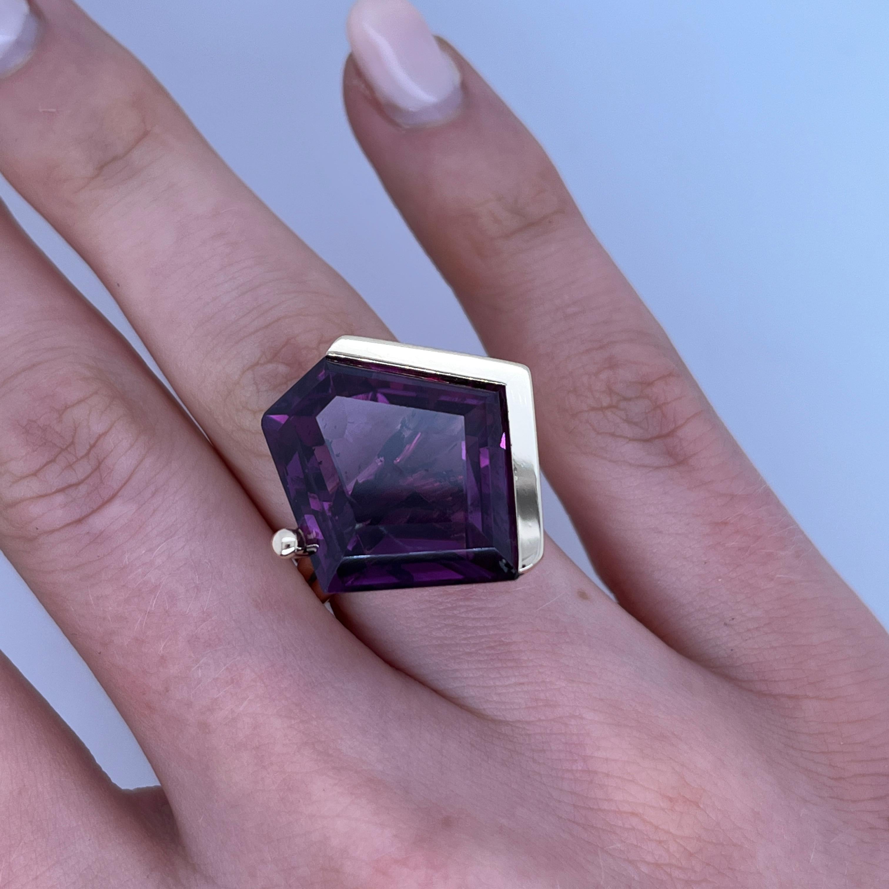 Dress Ring mit natürlichem Amethyst besetzt, gefertigt aus 14 Karat Gelbgold. Dieses auffällige Schmuckstück zeigt in der Mitte einen rautenförmigen Amethysten, der den satten violetten Farbton des Steins zur Geltung bringt. Die schlichte