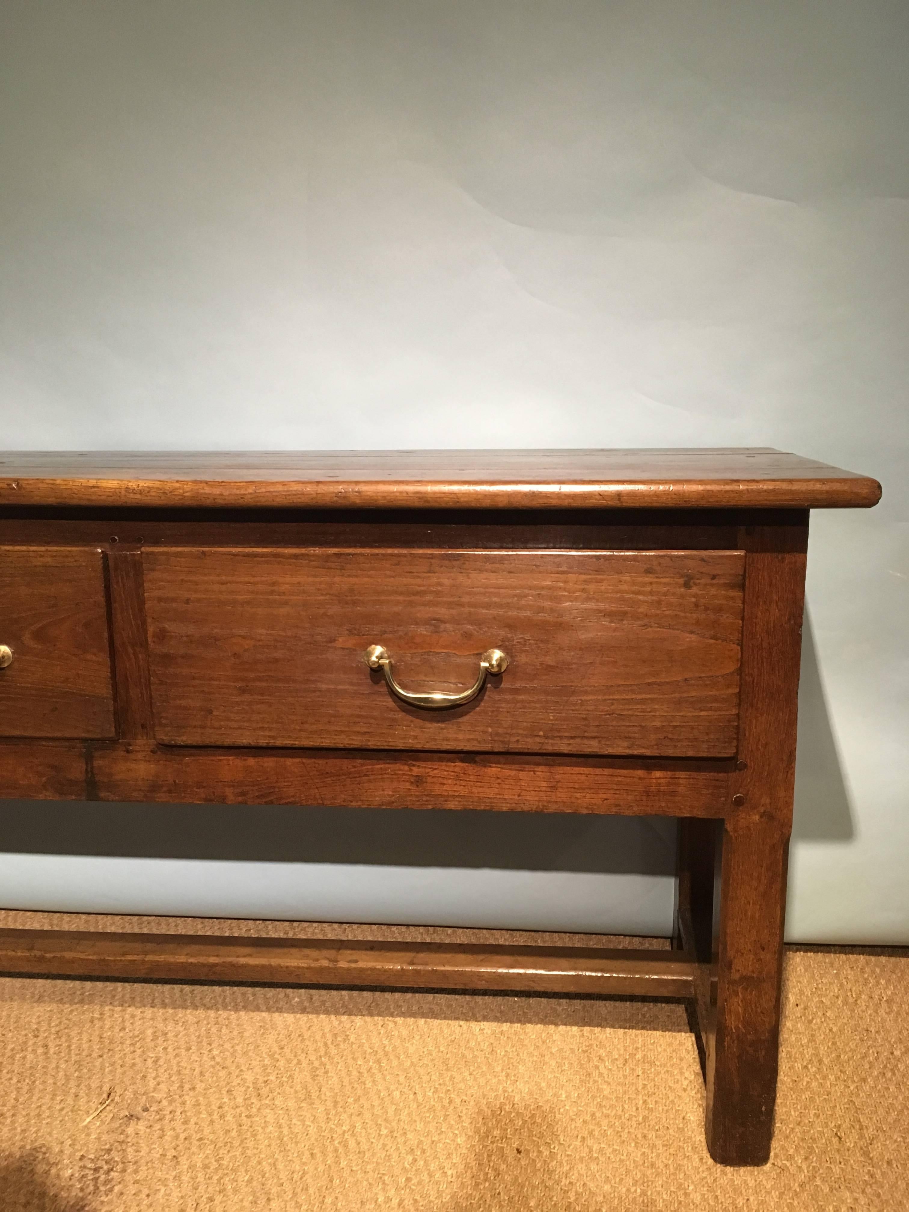 Fab early 19th century dresser base / server 

Dating to circa 1830s constructed from solid chestnut, three large drawers with original brass handles, you can see the indentations the handles have left over all these years, lovely panelled back so