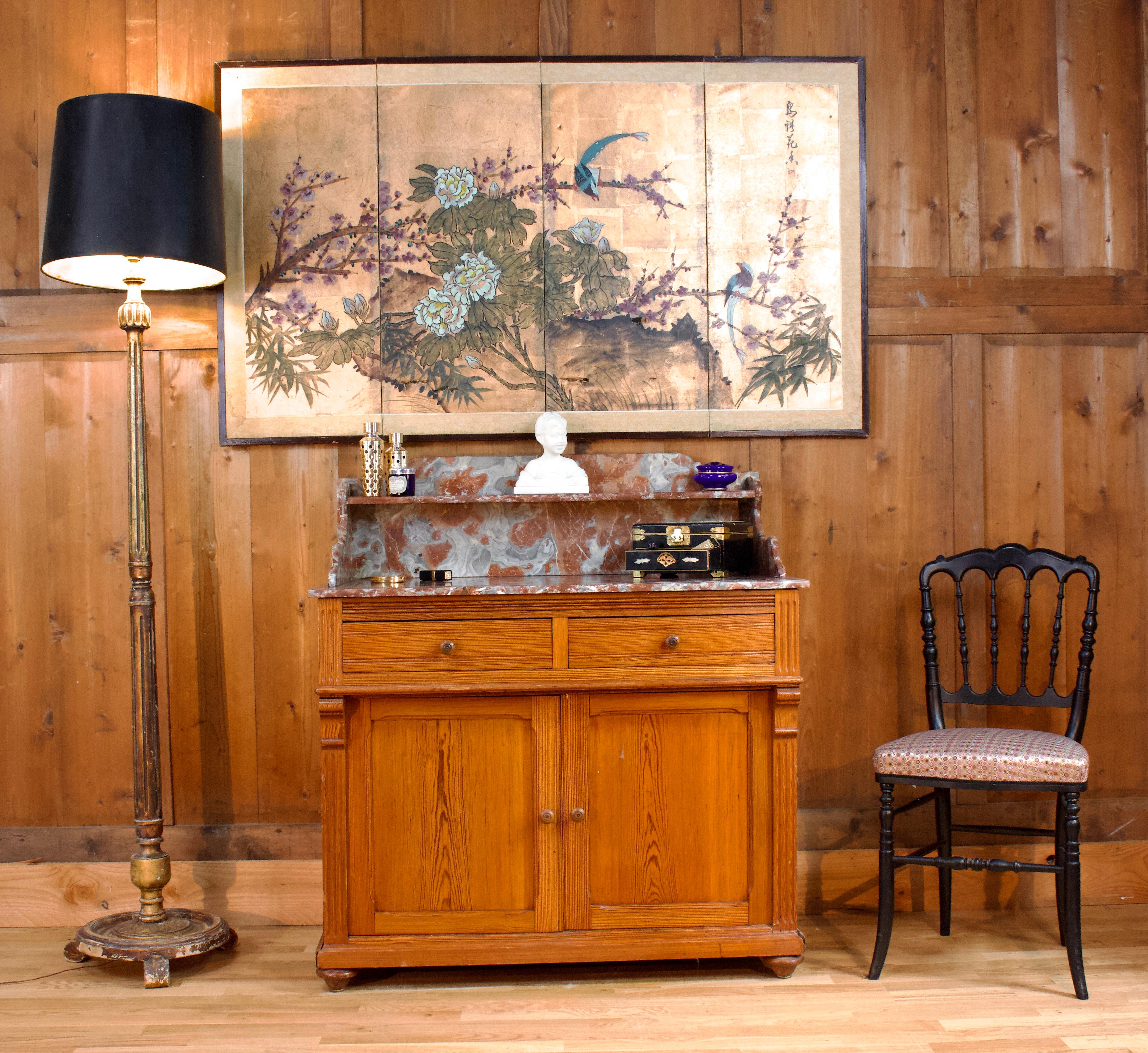 Bellissimo comò composto da due cassetti e due ante. In legno massiccio è composto anche da una lastra di marmo nei toni del rosso, del grigio e del bianco. Le decorazioni sono posizionate su ogni lato del mobile. Sulla parte superiore si trova un