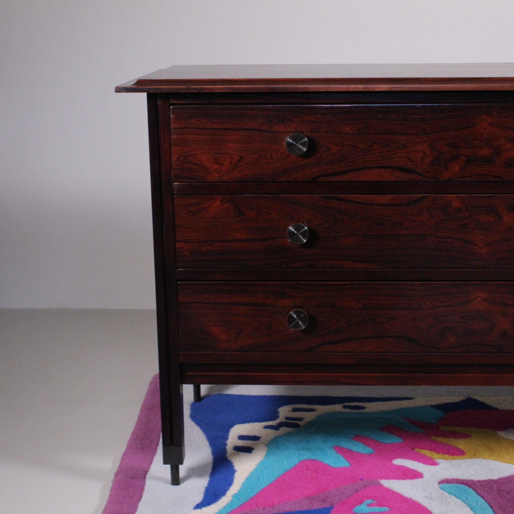 La cassettiera in legno massello disegnata da Calo De Carli per Sormani negli anni '60 rappresenta un'icona dell'arredamento d'epoca, con un mix perfetto di eleganza, preziosità e funzionalità. Questo pezzo di design incarna la maestria artigianale