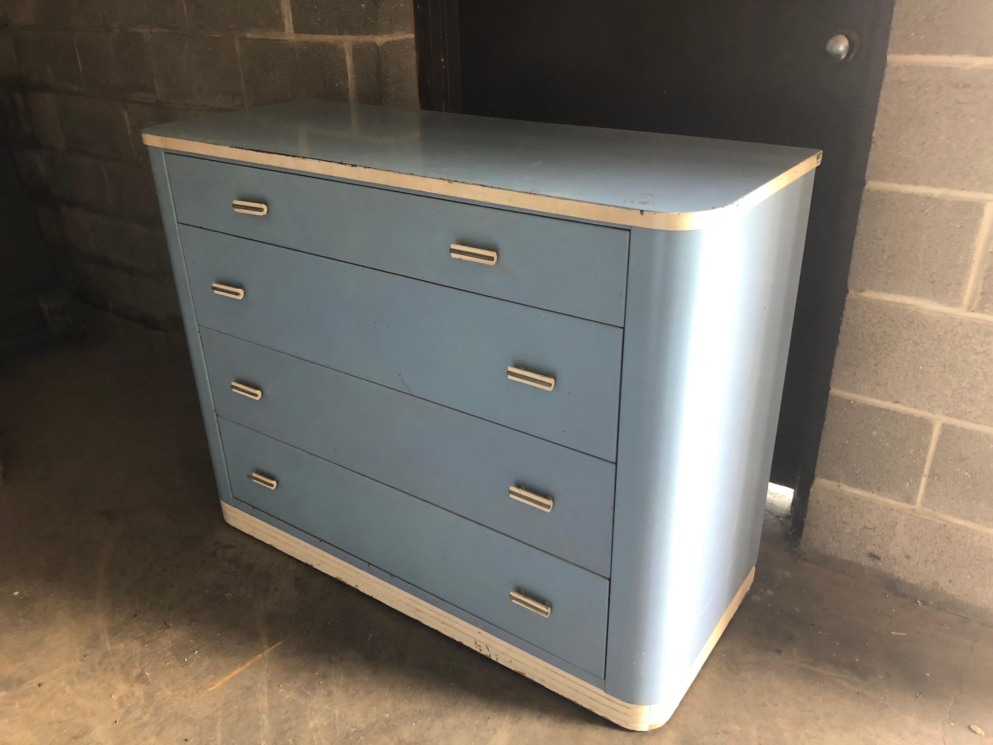 Dresser lowboy style by midcentury's Norman Bel Geddes for Simmons. Debuted at the Chicago World's Fair, 1932. In original cottage blue and white paint. Deco details evident via Bakelite handles, curved design and color. Solid, sturdy, drawers slide