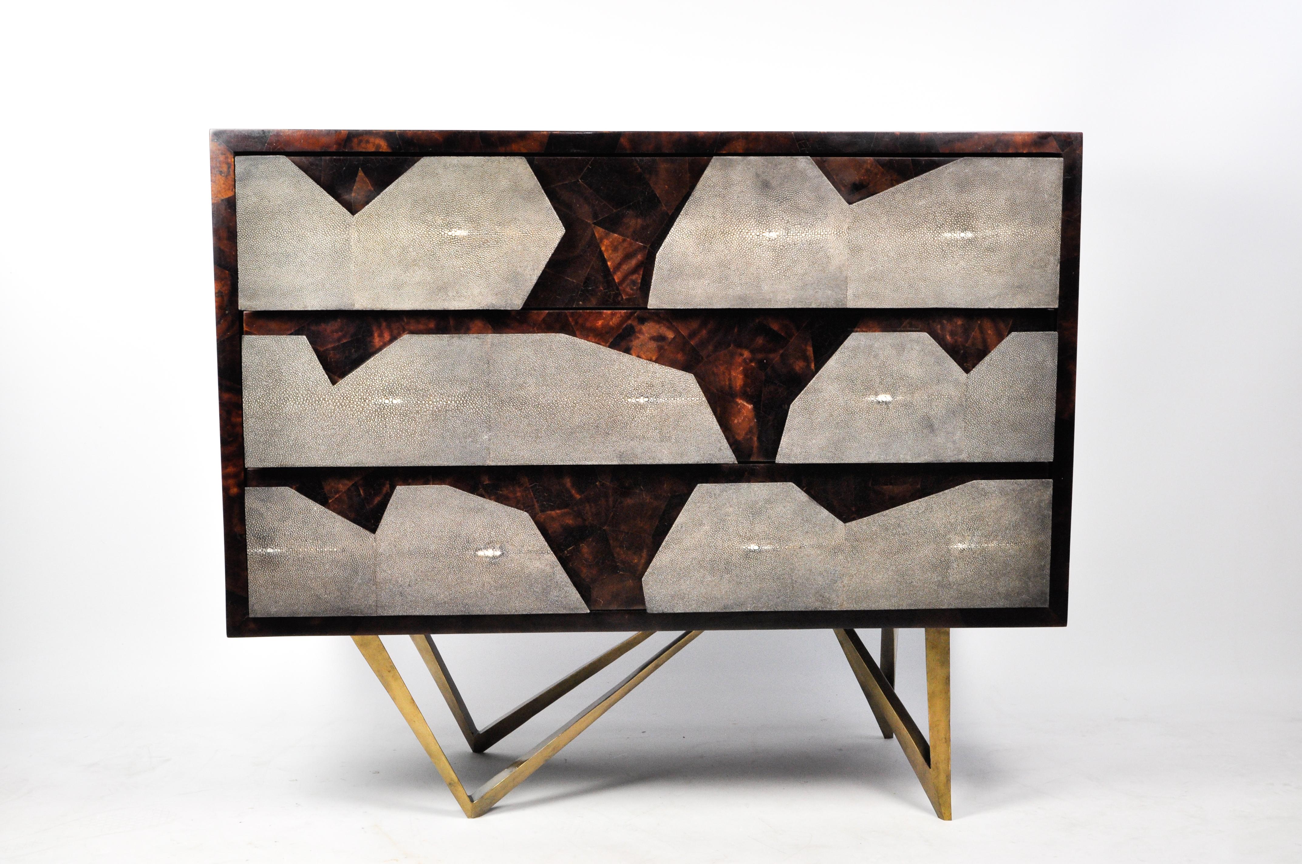 The REEF 3 drawer dresser is made of sea shell marquetry with shagreen decor on the front of the drawers.
The legs have an old brass patina.
The interior of the drawers are in black veneer.

The dimensions of this dresser are 39.37