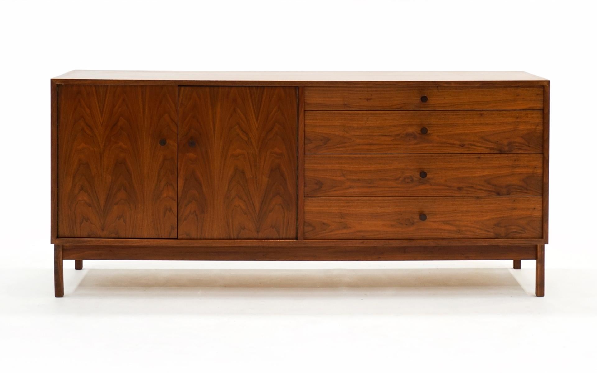 Walnut storage cabinet with rosewood pulls with four drawers and two doors revealing an adjustable shelf in the style of Milo Baughman for Glenn of California, 1960s. Beautiful figuring in the wood. Very good, completely original condition. No