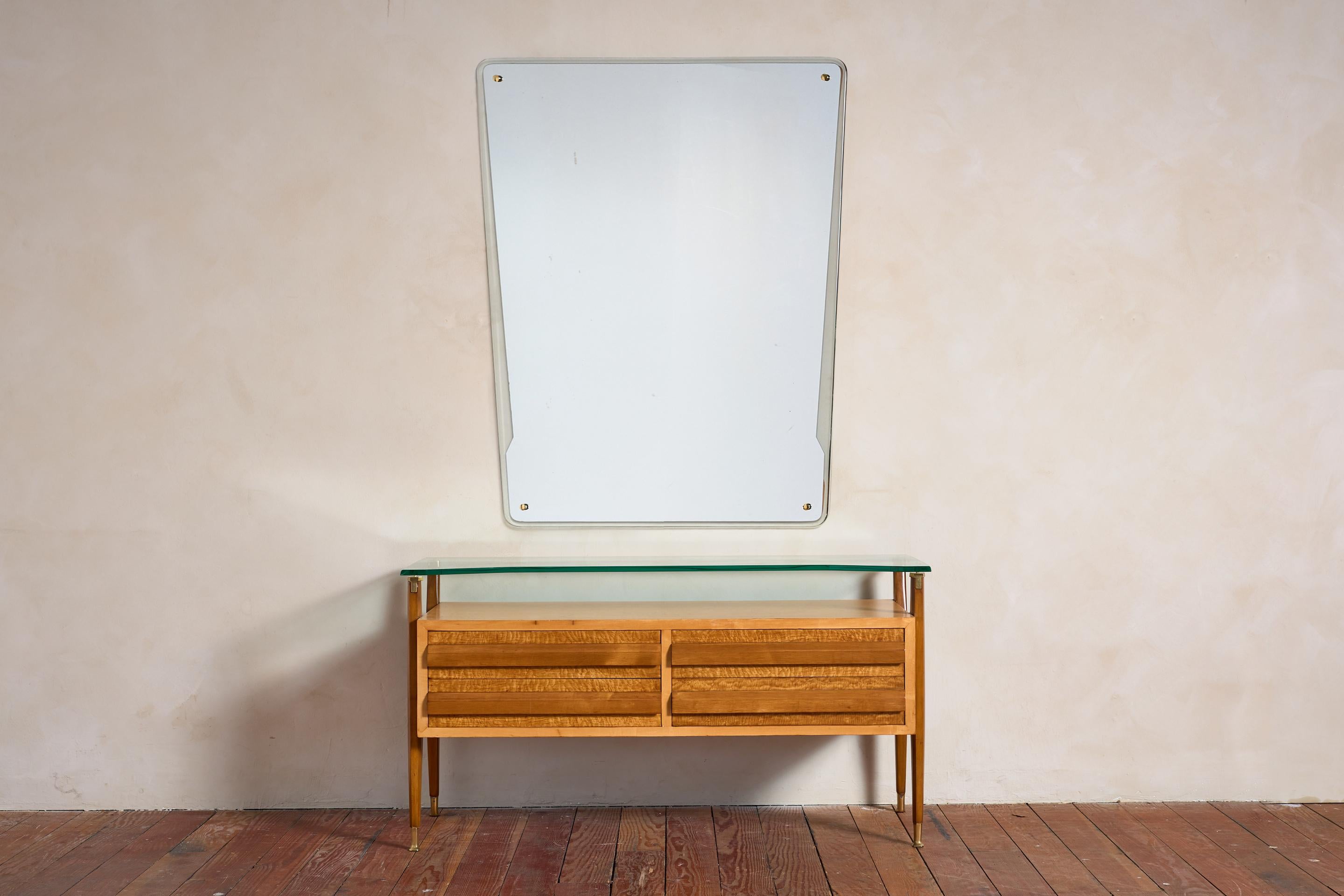 Stunning Dresser with Mirror by La Permanente Mobili Cantù , Italy 1950

The dresser features a figured wood front with sculptural drawer pulls, tapered brass legs, and a floating glass top. 

Matching large geometric mirror is framed in glass with