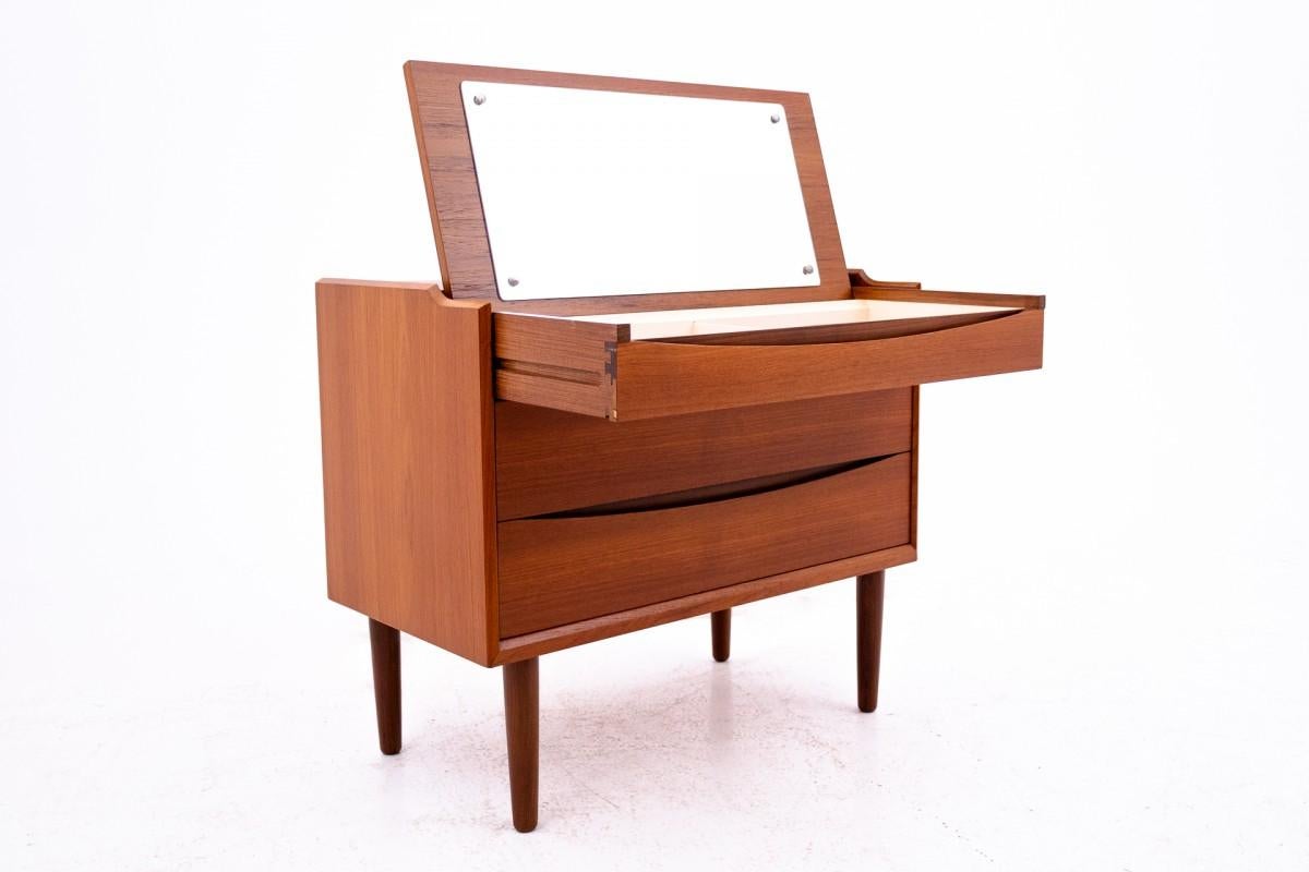 Commode en bois de teck.

Fabriqué au Danemark au milieu du XXe siècle.

Meubles en très bon état, après une rénovation professionnelle.

Le meuble dispose de 3 tiroirs spacieux, dont l'un est doté d'un miroir et de compartiments spéciaux pour les