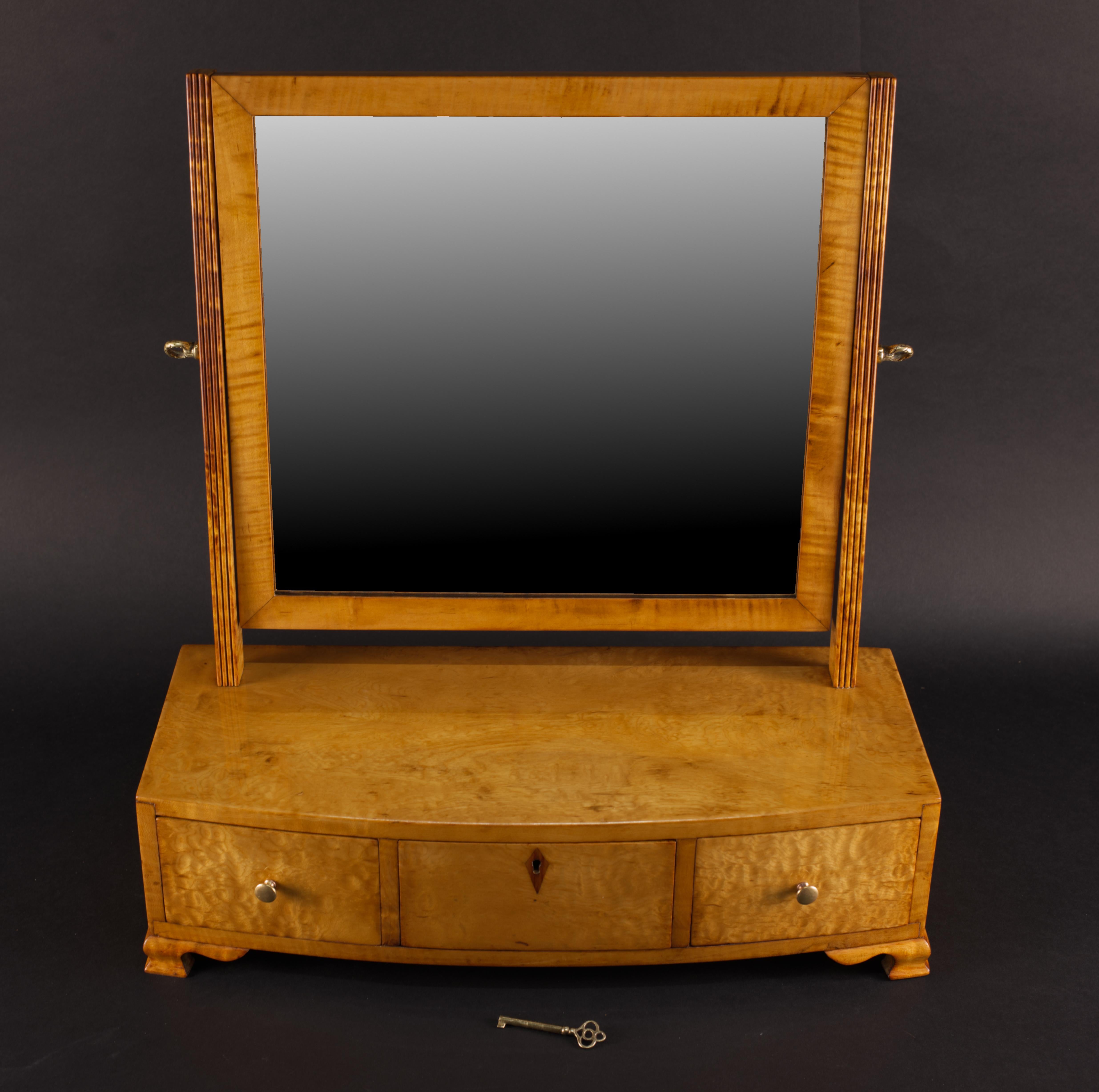 This is a lovely dressing table mirror from early 1800. It is made in highly figured American maple veneer and solids. Parts of the frame are American spruce. 
Because of the unique graining of the wood, French Polished shellac was chosen as a most