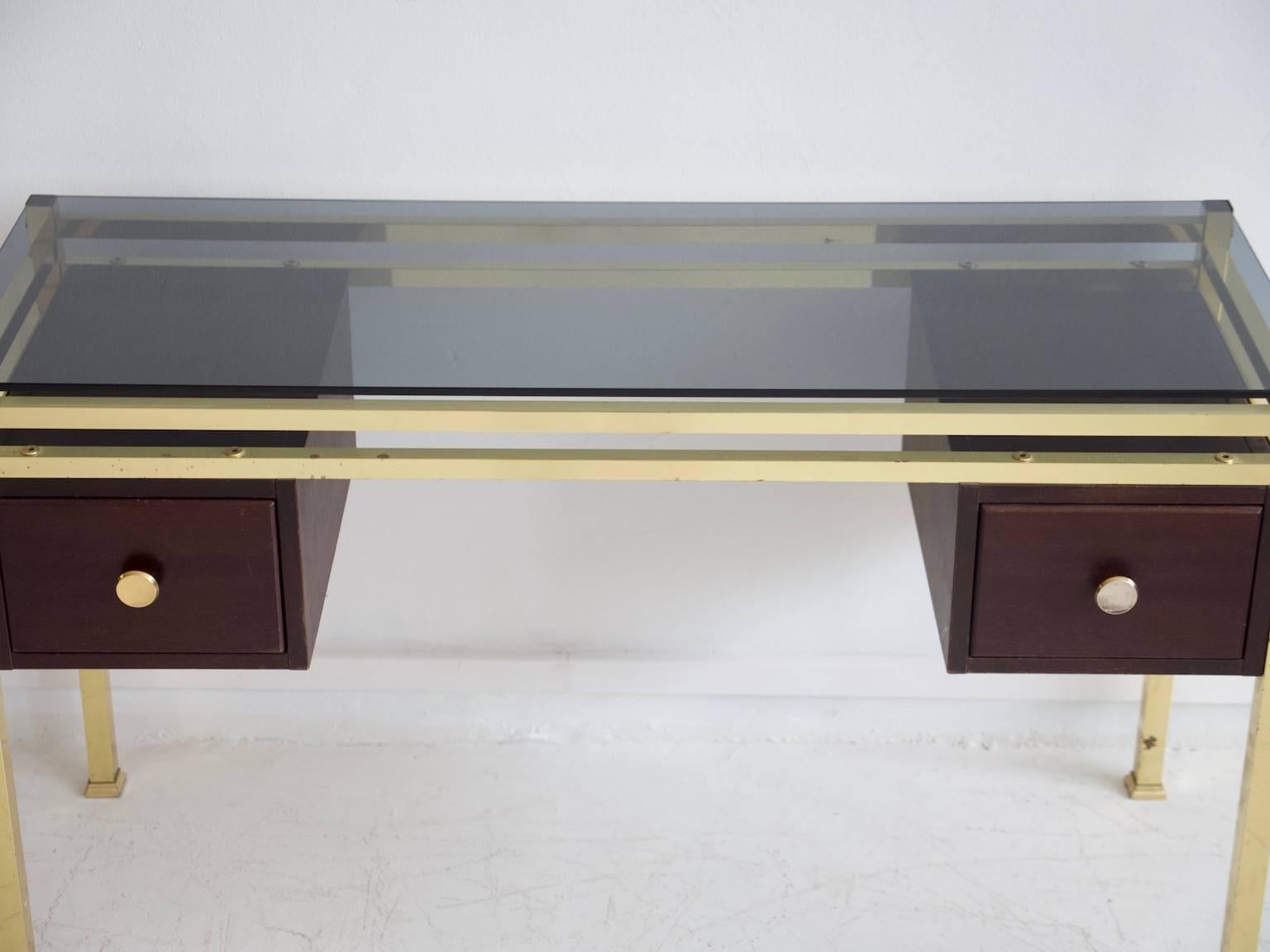 Vanity or console table with tinted glass top and two drawers made of stained wood. Brass frame shows minor age-related stains from circa 1970.