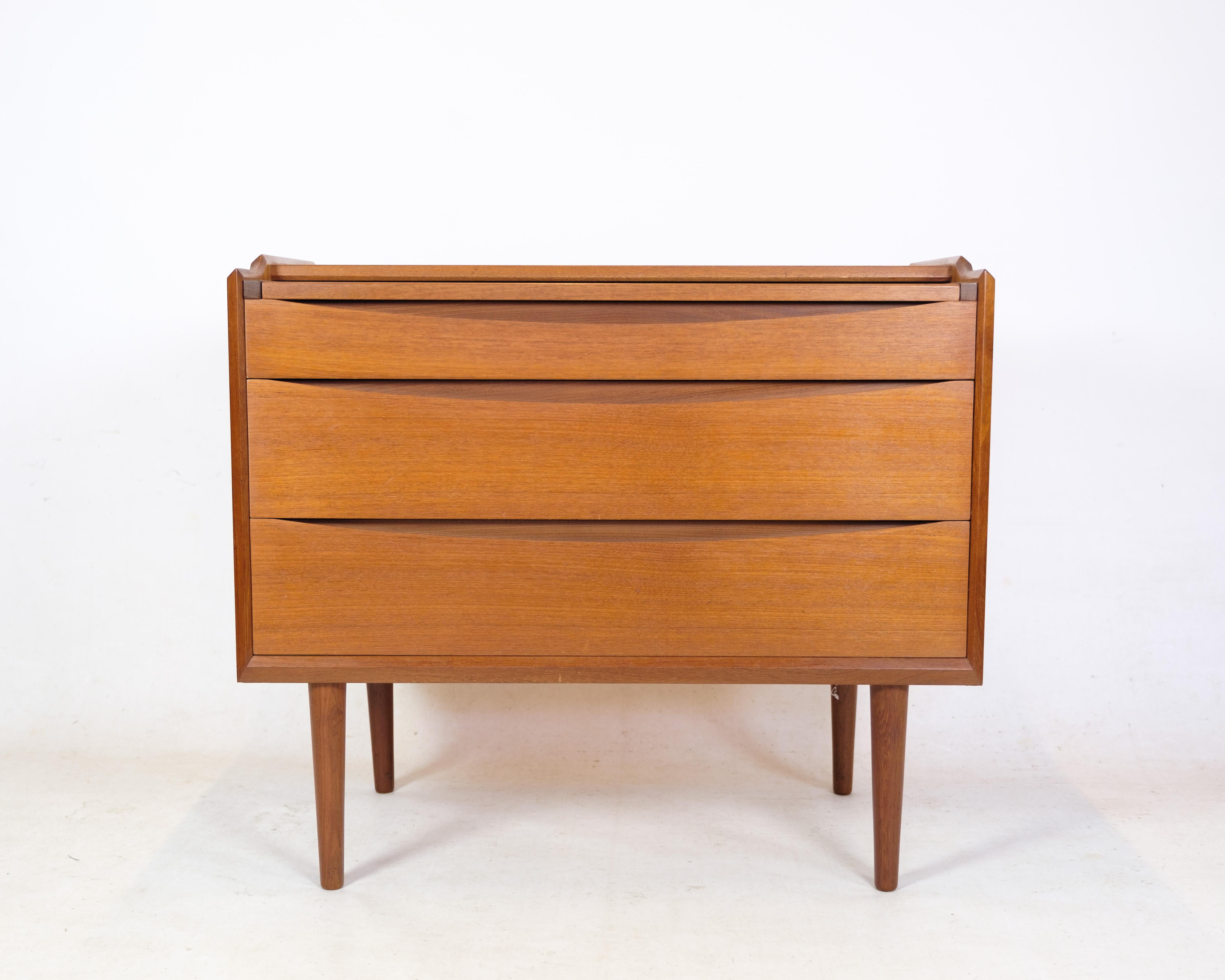 Dressing table veneered with teak wood, front with fold-up mirror panel, including two drawers. Manufactured at Ølholm Møbelfabrik, stamp from here. The 1960s. H. 80 W. 86 D. 46 cm