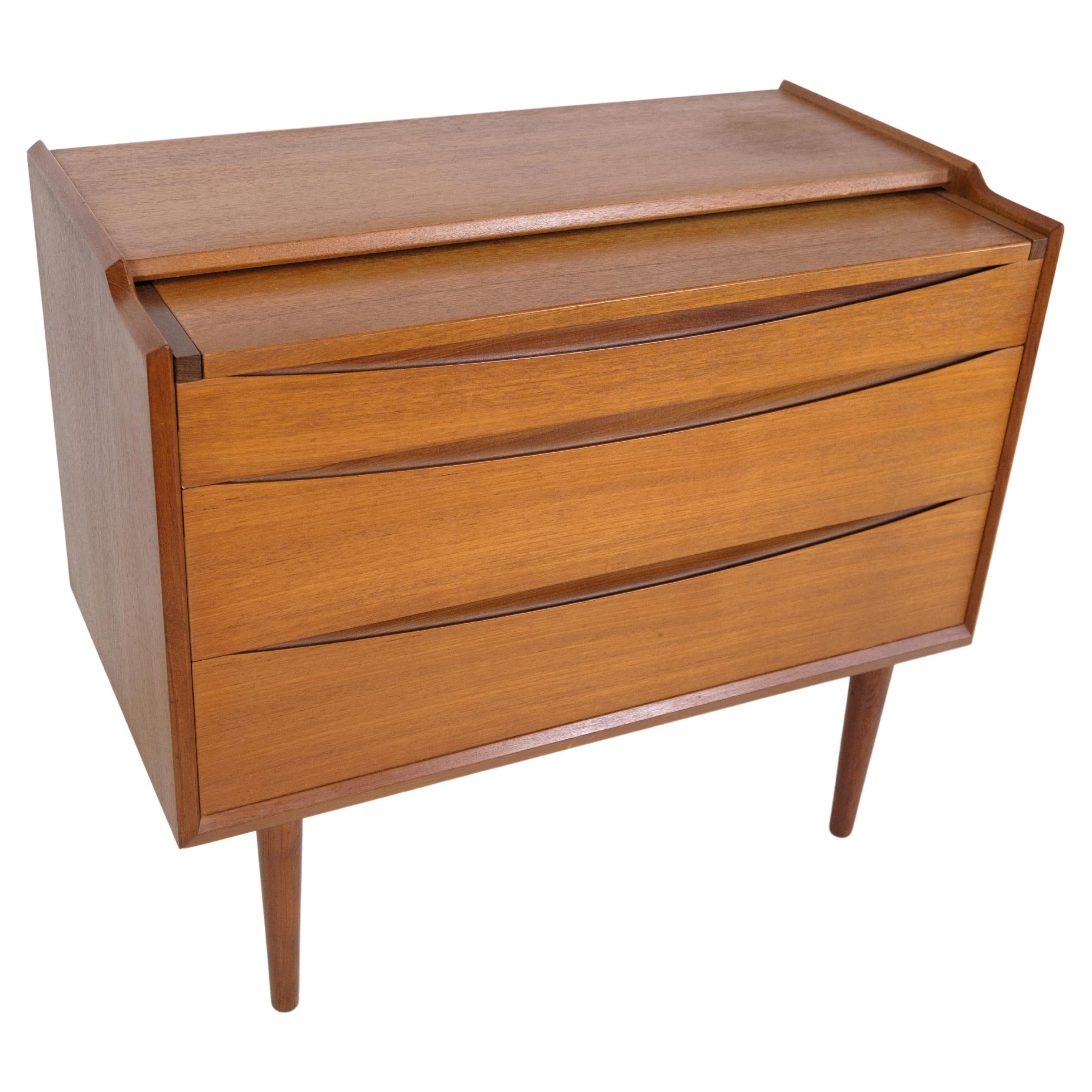 This dressing table, veneered with teak wood and manufactured by Ølholm Møbelfabrik in the 1960s, makes a beautiful and functional addition to any bedroom or dressing area. Its elegant design includes a front with a fold-out mirror panel, creating a