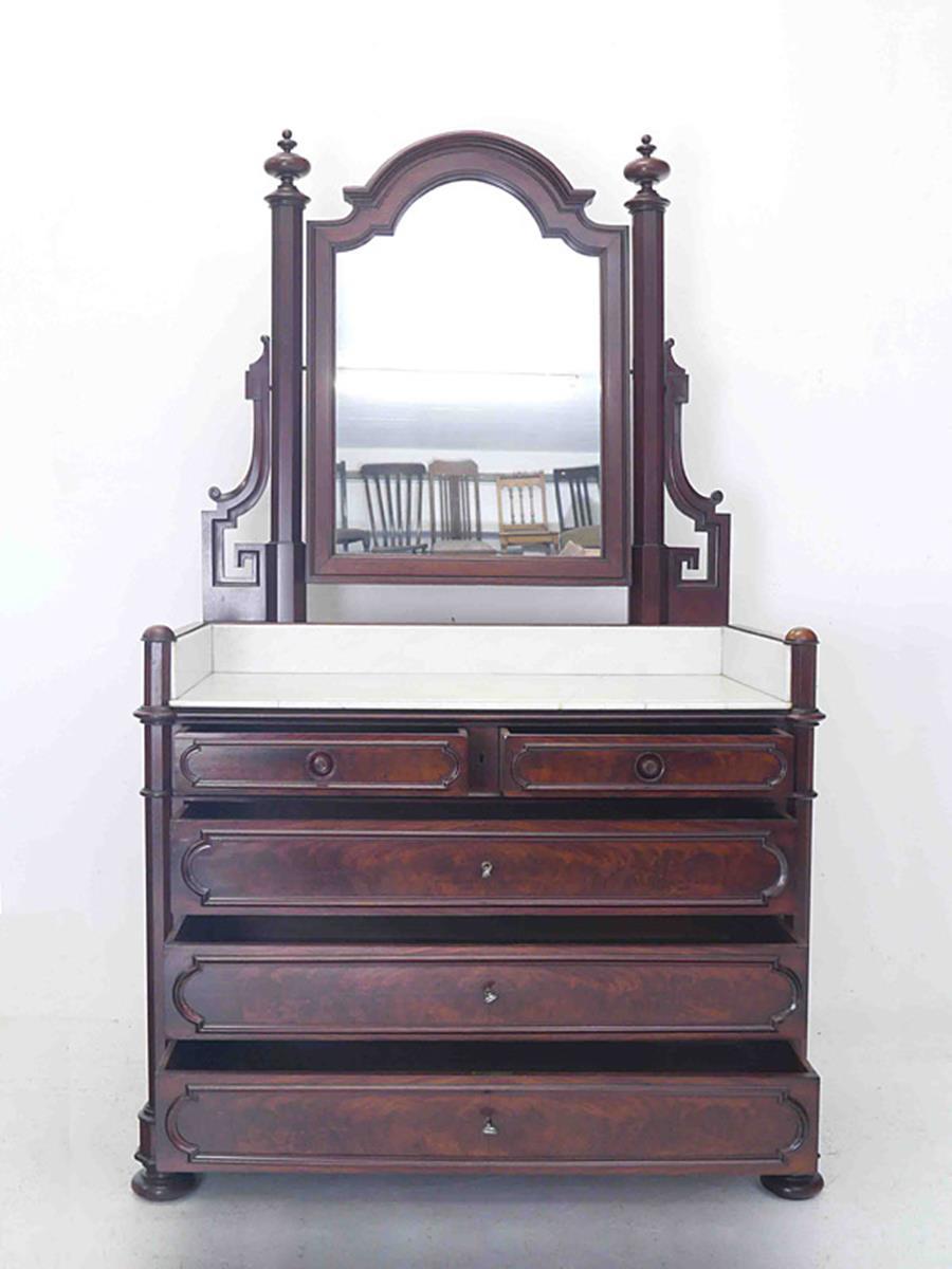 This wonderful antique dressing table circa 1850 is equipped with a mirror attachment.
The mirror chest of drawers is made of mahogany veneer on oak.
The facet cut mirror is attached to two hexagonal columns with voluted flanks.
The mirror has