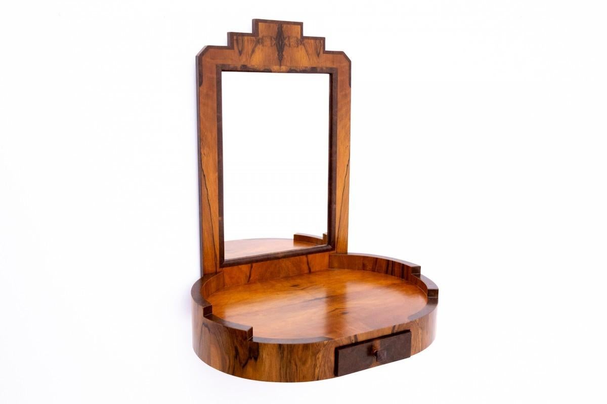 Art Deco dressing table with chair from the 1950s.

A dressing table in a geometric form characteristic of the Art Deco style. The furniture has one small drawer, a spacious top ideal for storing utility and decorative items. The dressing table is