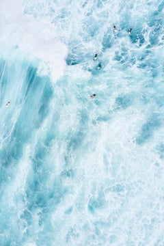 Un groupe de surfeurs attendant leur tour dans les eaux vives d'une vague qui passe.