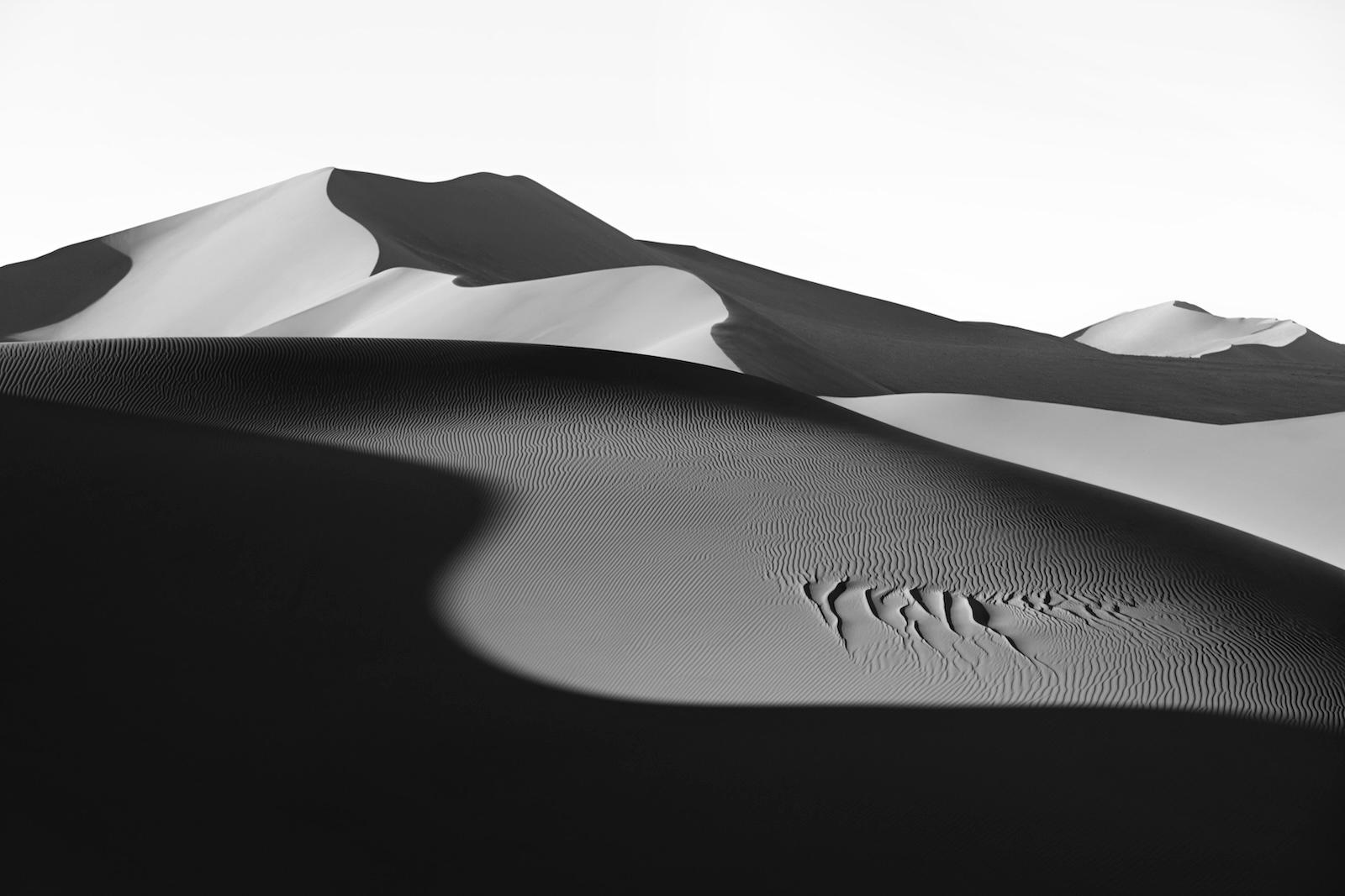 A sensuous curve of light dances across some of the largest sand dunes in the wo - Photograph by Drew Doggett