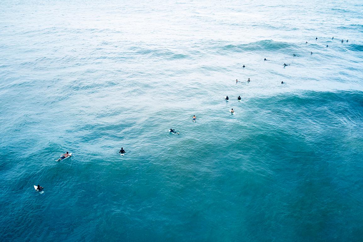 Drew Doggett Landscape Photograph - Aerial View of Surfers Waiting for Waves, Color Photography, Horizontal