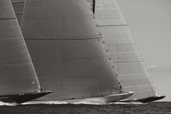 Black and white photograph featuring three world-class racing yachts