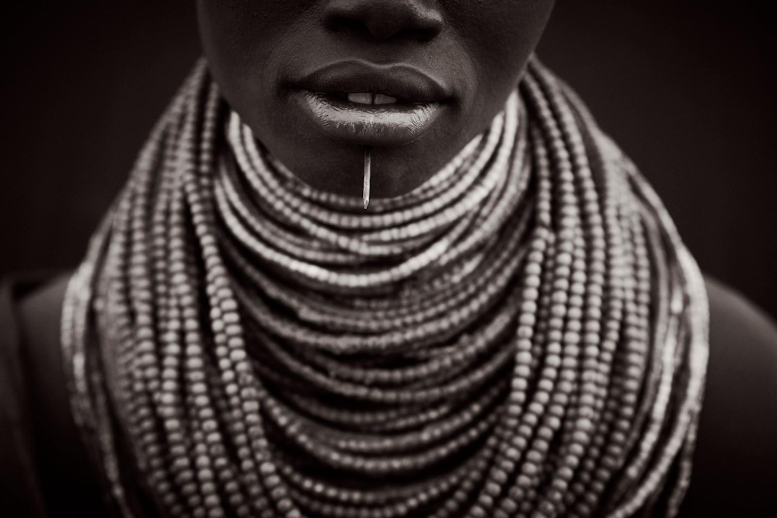 Portrait en noir et blanc d
une femme de la tribu Karo à la lèvre inférieure percée. - Photograph de Drew Doggett