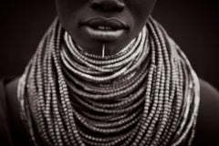 Black and white portrait of a Karo tribeswoman with a pierced lower lip