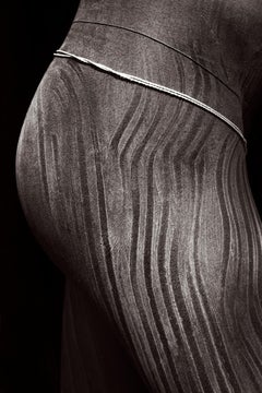 Black and white portrait of a Suri warrior adorned with traditional body paint