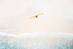 En esta imagen aérea, un surfista solitario se toma un momento antes de adentrarse en el mar