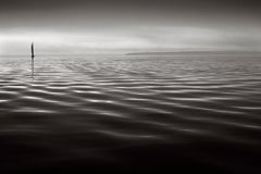 Meditative black and white photograph featuring a lone yacht on calm waters