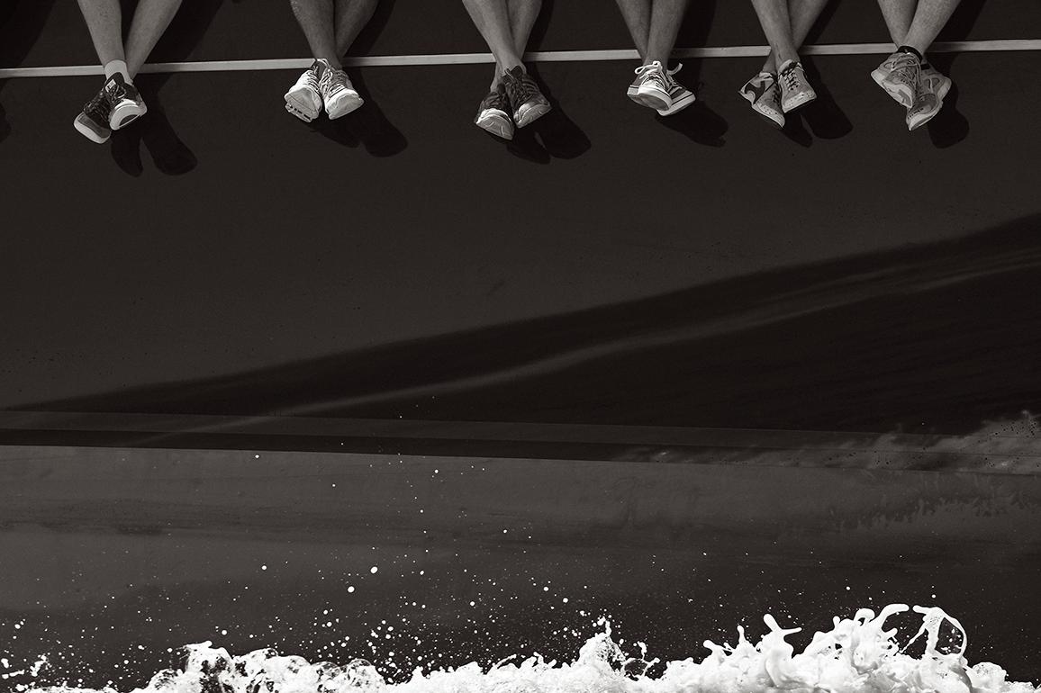 Drew Doggett Portrait Photograph - Sailor's Feet Hanging Over the Deck of the Iconic Yacht Rainbow, Design-Inspired