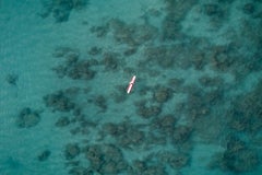 Surfer waiting above a reef in this aerial photograph creating a beautiful scene